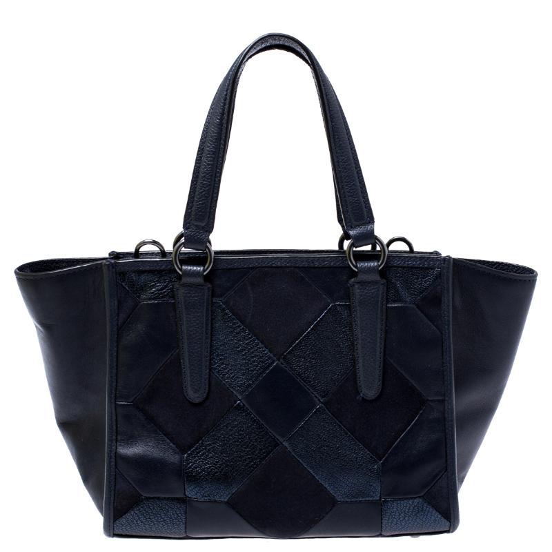 An ideal bag that calls out to the modern woman in you. Crafted from navy blue leather, this Coach bag features patchwork design on the front. It is held by dual handles and its fabric-lined interior can hold more than just essentials.

Includes: