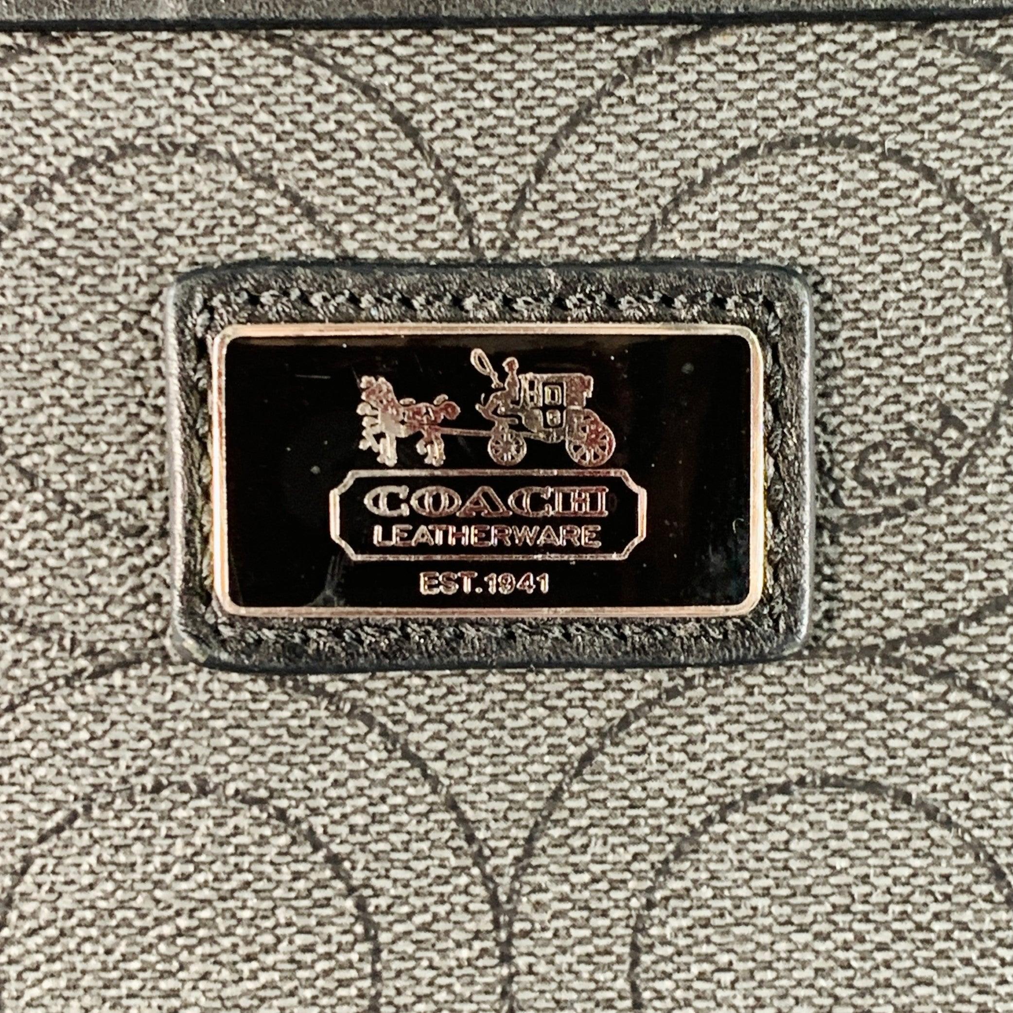 Borsa COACH
in tela spalmata grigia e nera con stampa del logo, tracolla regolabile in nylon nero e chiusura a zip. Segni di usura sugli angoli e sulla cerniera. Così com'è. 

Contrassegnato:   F1069-70267 

Misure: 
  Lunghezza: 10,75 pollici