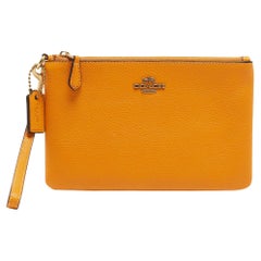 Pochette à fermeture éclair en cuir orange de Coach