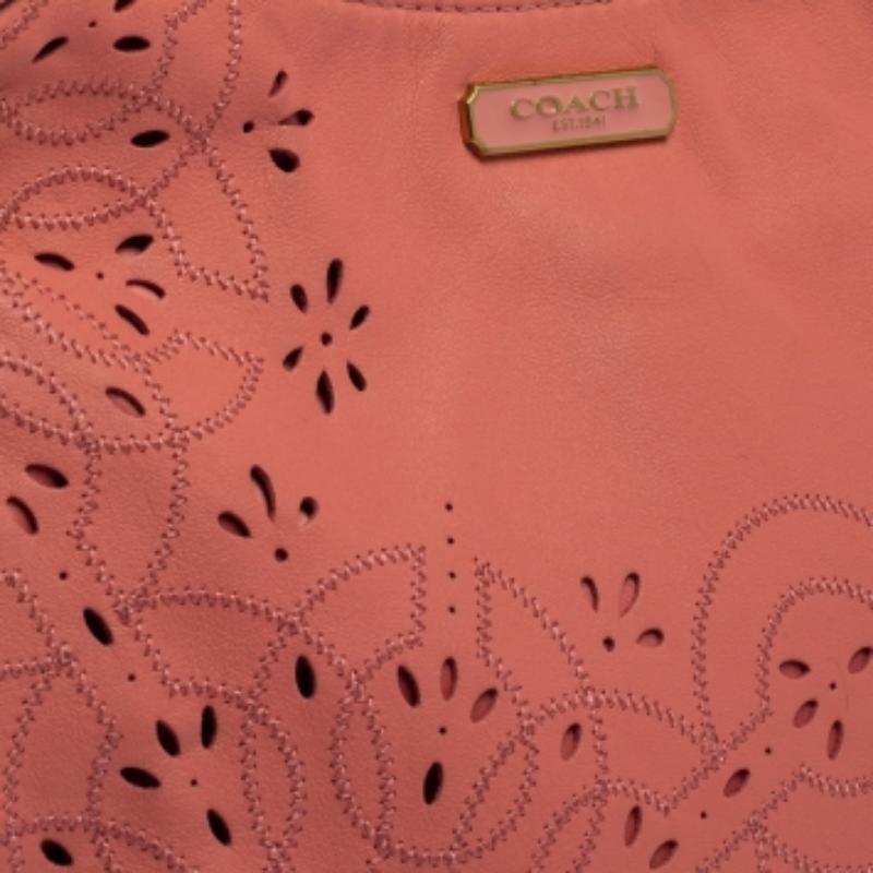 Step out in style with this hobo from Coach. It is crafted from pink leather and styled with floral cutouts on the exterior. The bag, equipped with two top handles and satin-lined compartments, is perfect to flaunt on your shopping trips and casual
