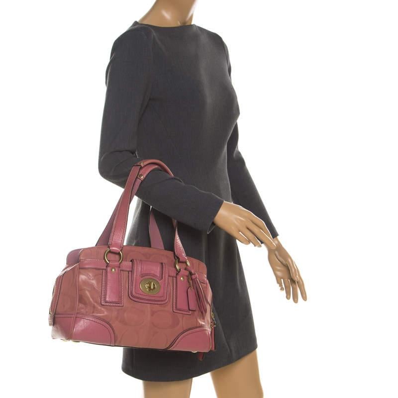 This stunning satchel is from the house of Coach. Crafted from leather, and lined with satin on the insides, the bag features a pink exterior with a turnlock on the front and dual handles. 