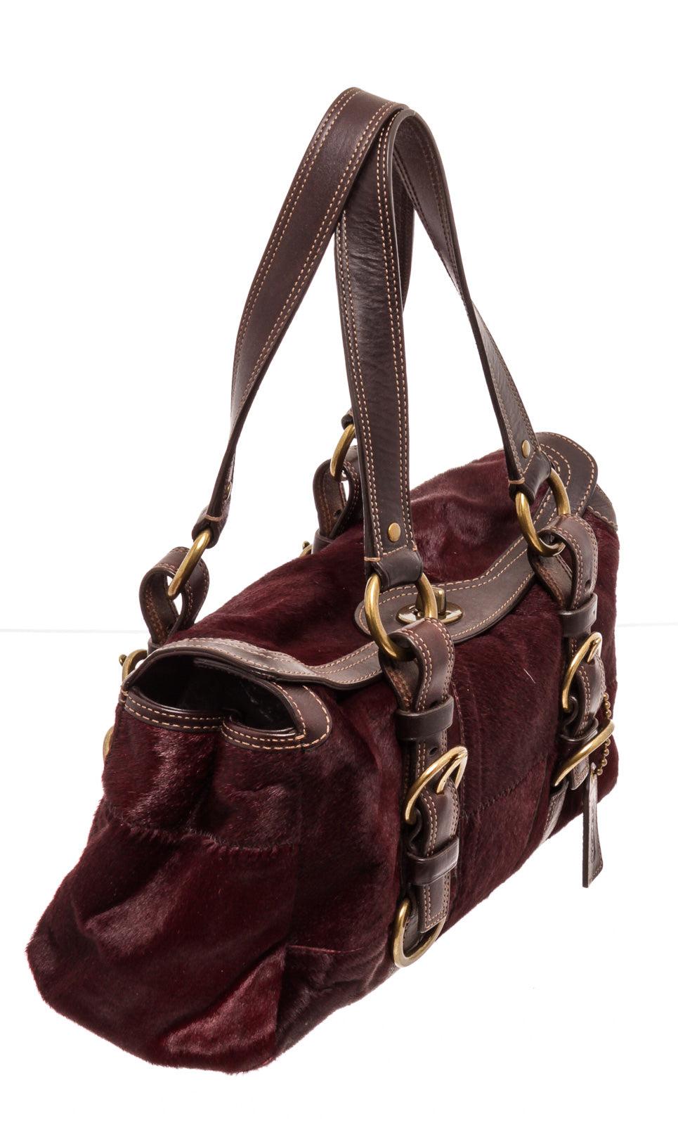 Coach red limited edition pony hair turnlock satchel with gold-tone hardware, dual flat top handles, brown leather trim, red silk interior lining, three interior pockets; one with zip closure and overall turnlock closure at top.
25095MSC