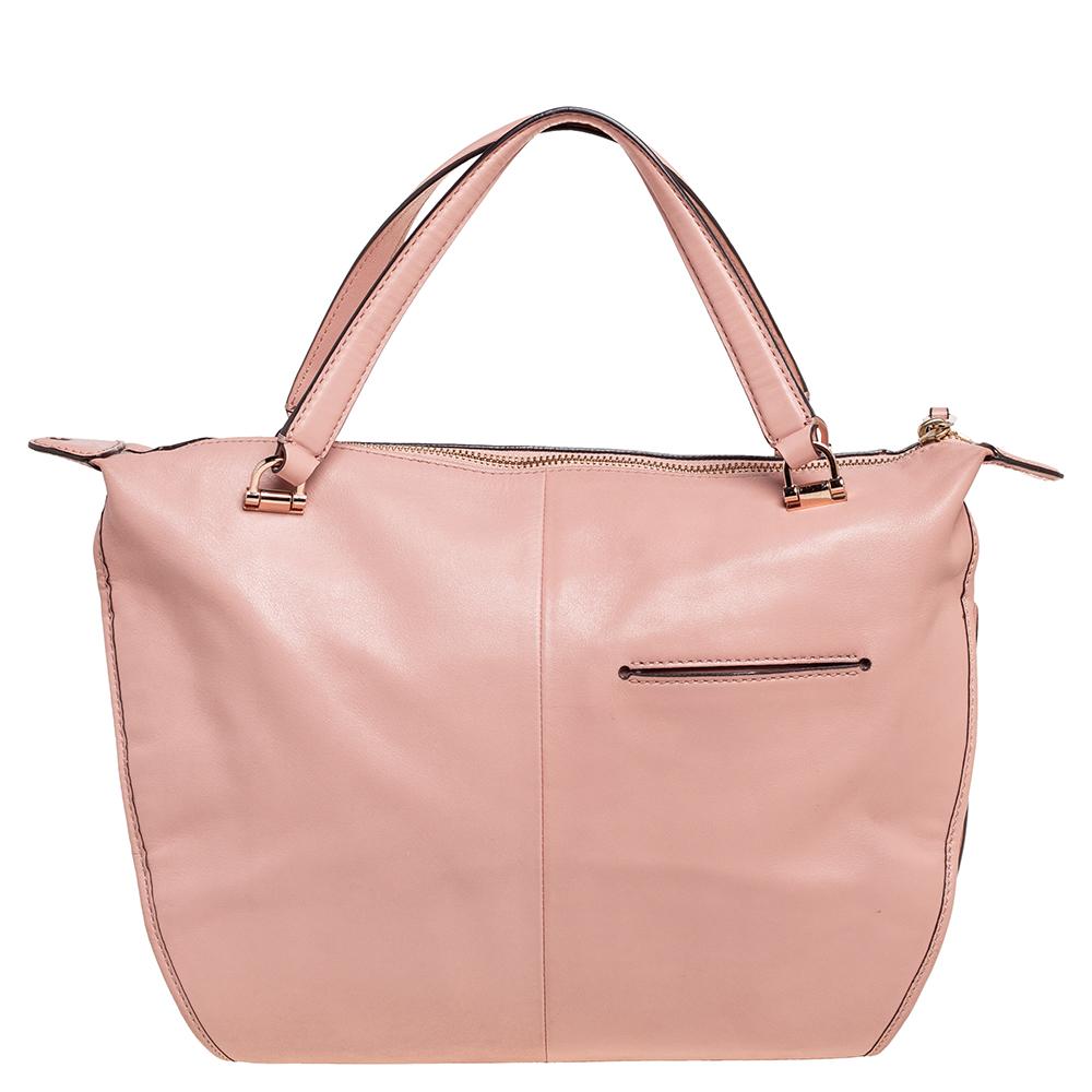 Chic in design and appearance, this Smythe satchel from Coach will be your favorite bag in no time. It is made from salmon-pink leather and features gold-toned hardware, a shoulder strap, and a fabric-lined interior. Carry this bag and exude nothing