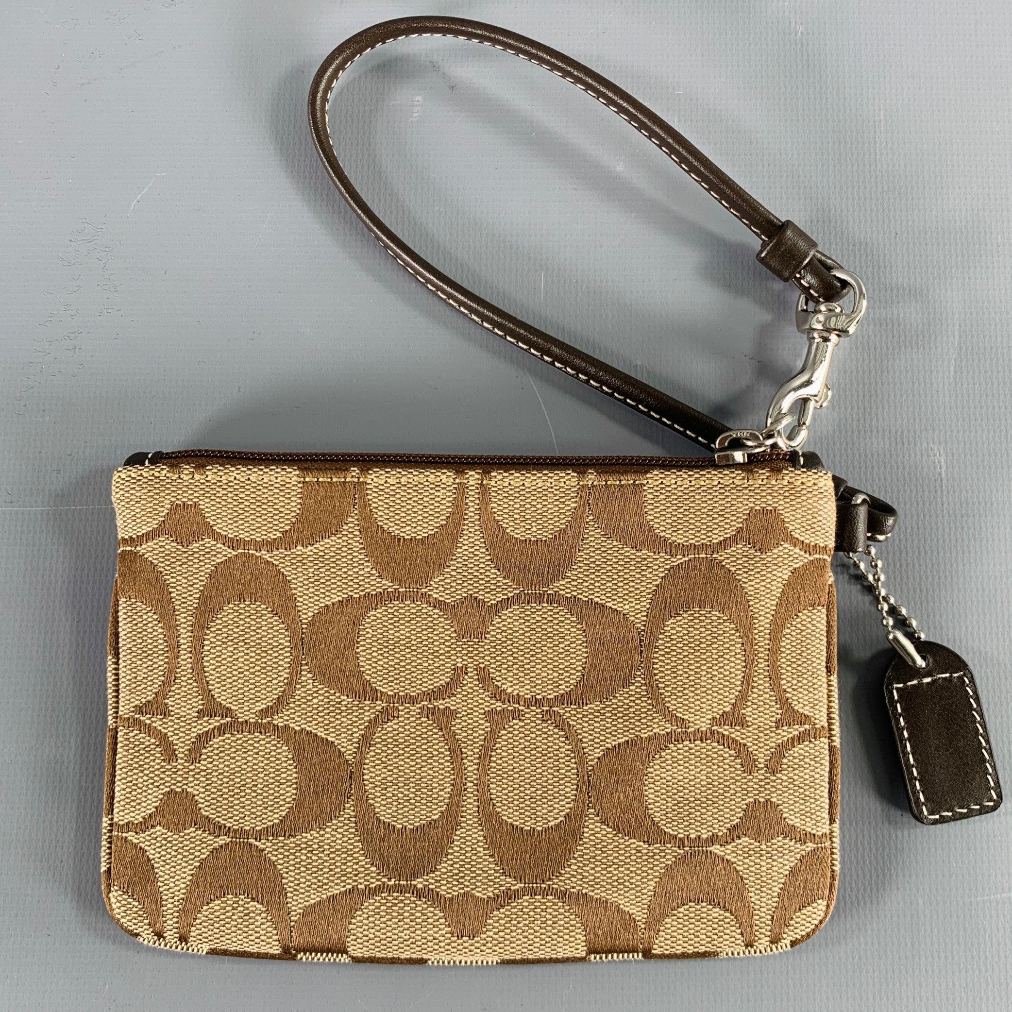 Vintage COACH wristlet in a taupe and brown fabric featuring signature monogram pattern,
 and zipper closure attached to leather strap.Excellent Pre-Owned Condition. 

Measurements: 
  Length: 5.75 inches Height: 4 inches  
  
  
 
Sui Generis