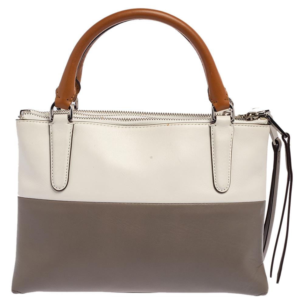 This chic Coach tote might just become the most loved accessory in your closet. Crafted from leather, it carries a colorblock design and the brand label printed on the front. The bag is equipped with two handles, a shoulder strap, and a spacious