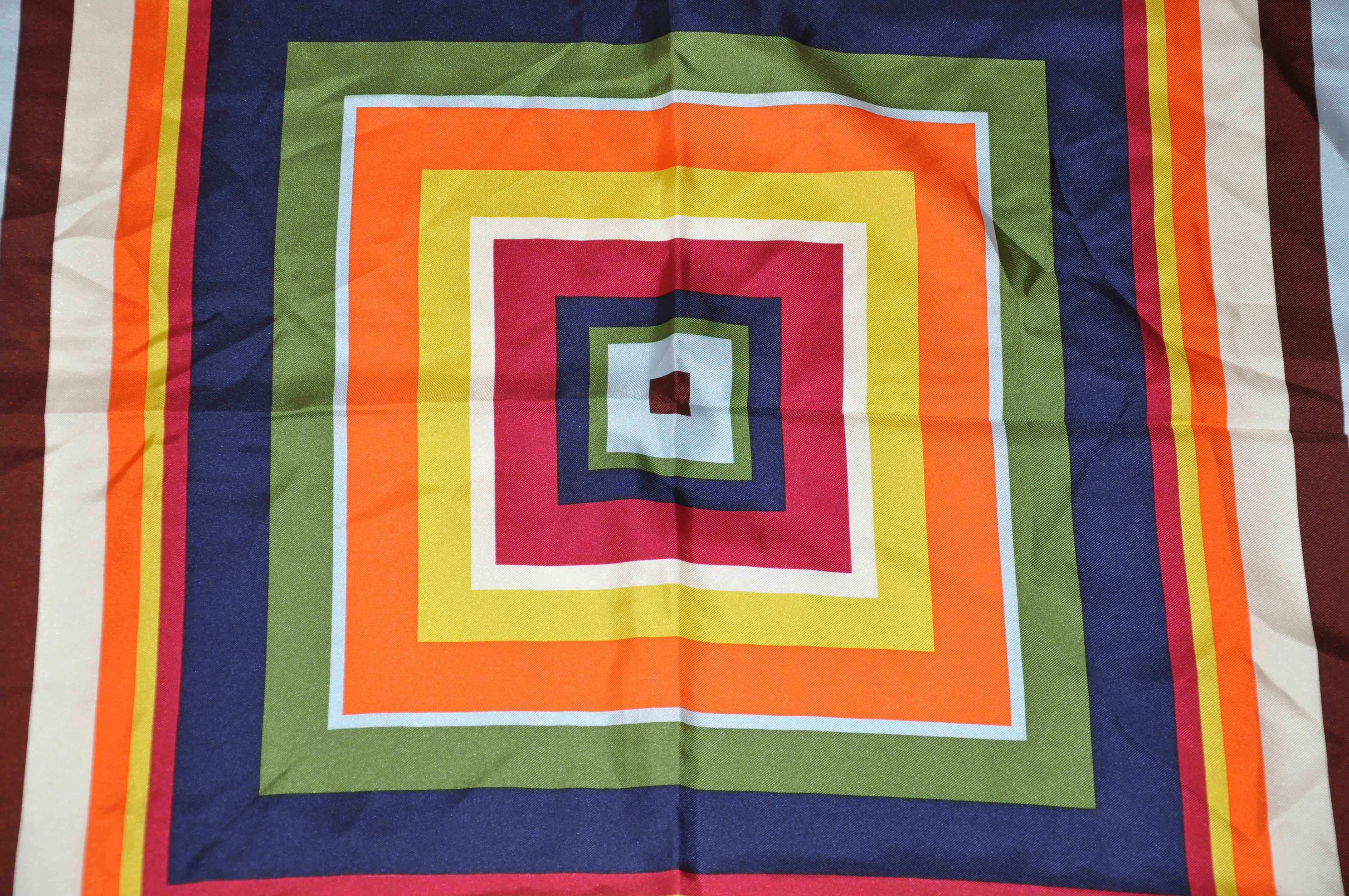 Coach vivid and colorful multicolor overlapping square silk scarf accented with hand-rolled edges, measures 26 inches by 27 inches. Made in China.