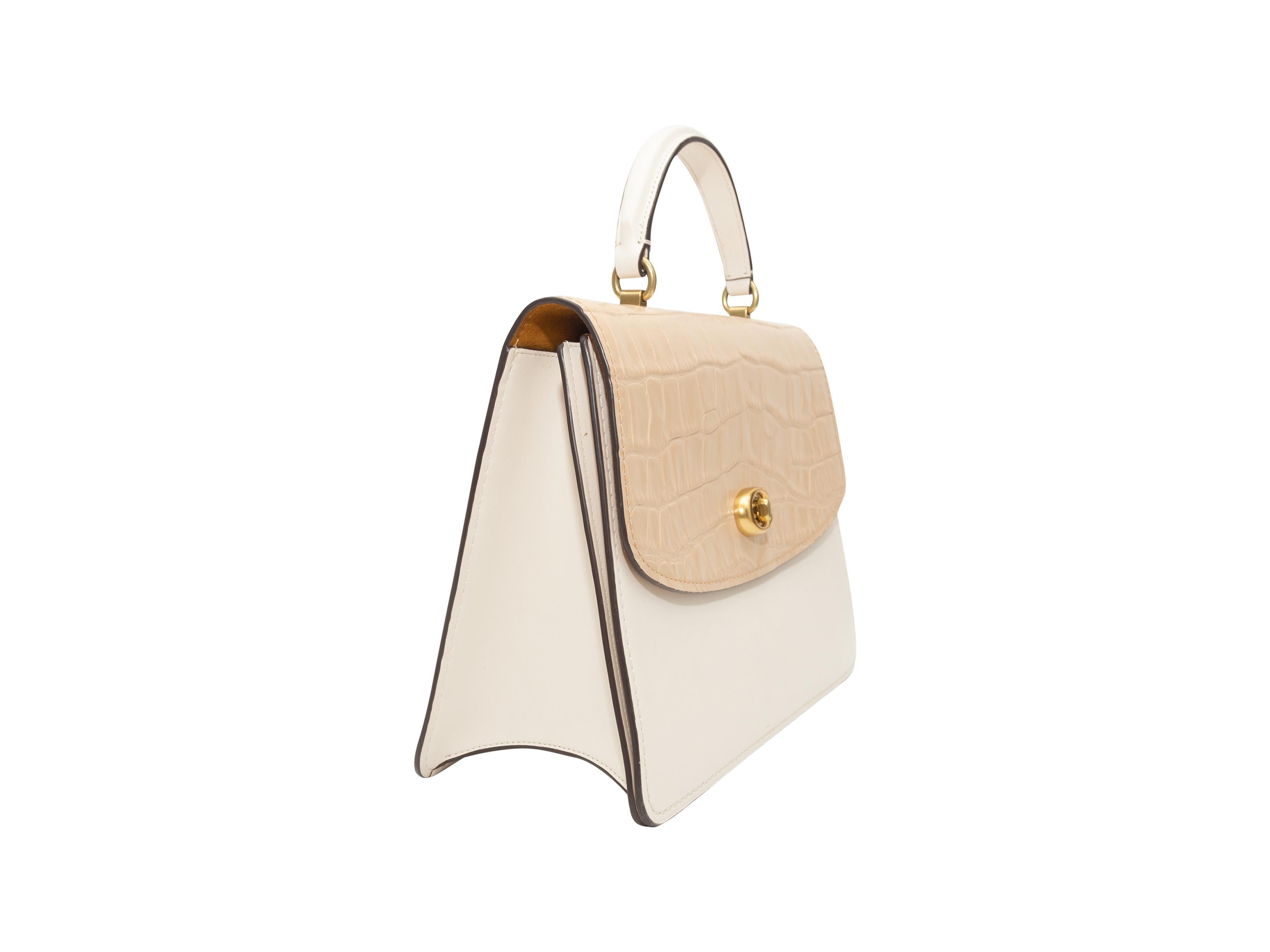 Product details: White and cream leather and suede flap bag by Coach. Gold-tone hardware. Yellow suede interior. Interior zip pocket. Single top handle. Optional shoulder strap. 11.5