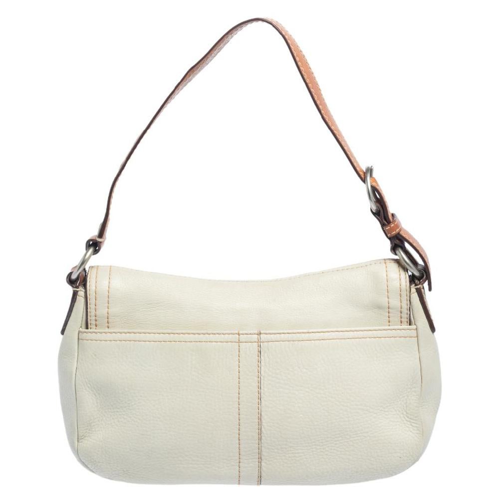 Now here's a bag that is both stylish and functional! Coach brings us this gorgeous shoulder bag that has been crafted from leather and designed with a flap that opens up to a fabric interior capable of carrying all your essentials. The piece is