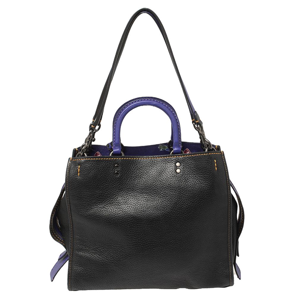 Whimsy and striking, this tote bag by Coach x Disney is for women who love making a statement. Crafted from quality leather, it comes in lovely hues of black & purple. The bag is styled with 'Haunted Forest' patches, contrast stitching, dual
