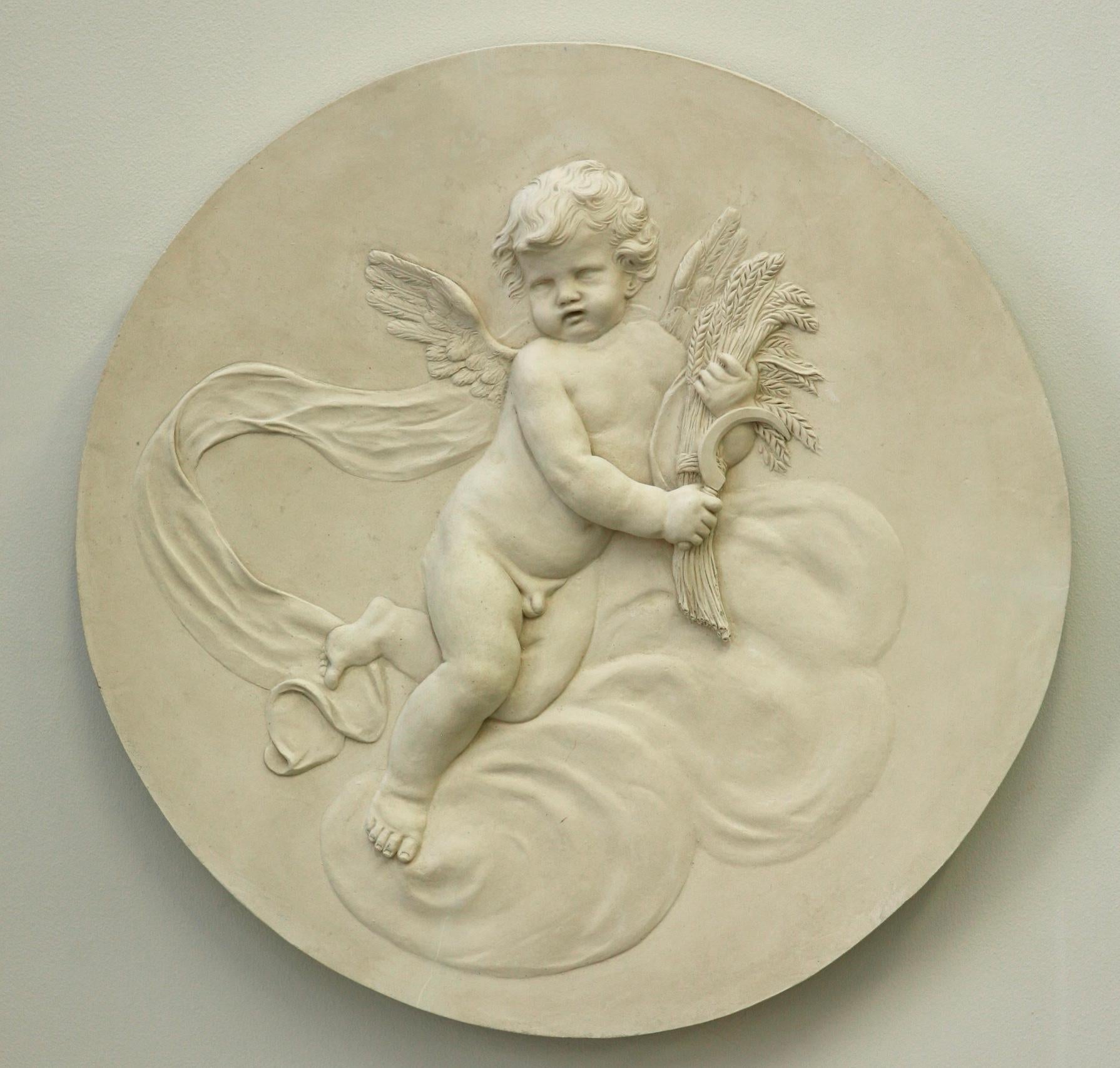 Coade Studio dekoratives Rondell mit der Darstellung eines auf einer Wolkenformation schwebenden Cherubs "Summer". Summer" hält Weizen in der Hand. In zartem Flachrelief modelliert. Die vier Jahreszeiten-Rondelle sind von den Coade-Designs aus dem