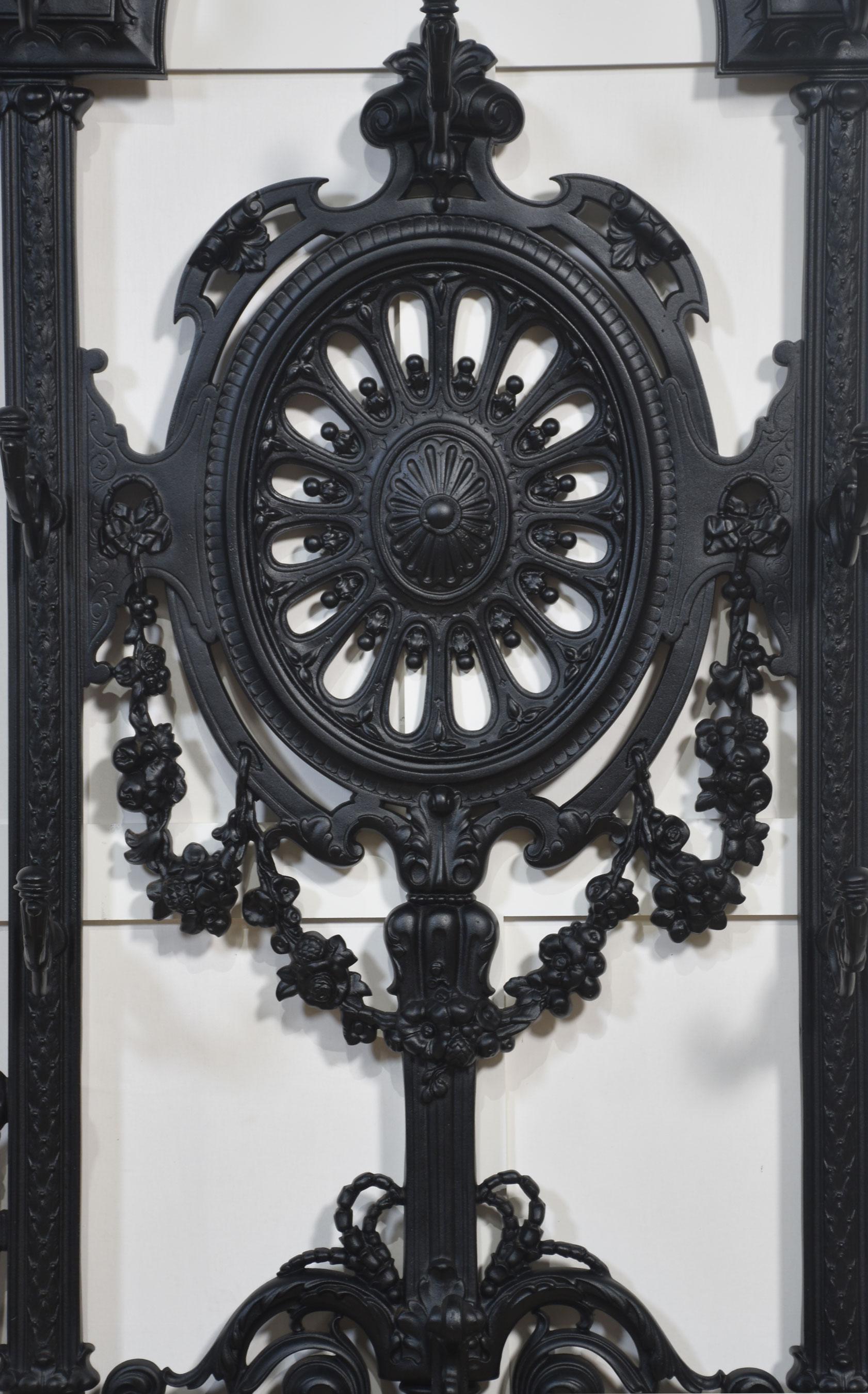 Porte-hôtel en fonte de style Coalbrookdale, de forme arquée, avec huit crochets à volutes, l'ovale central percé avec des feuilles et des fruits moulés, au-dessus de deux compartiments à parapluie, avec des volutes et des treillis au-dessus d'une
