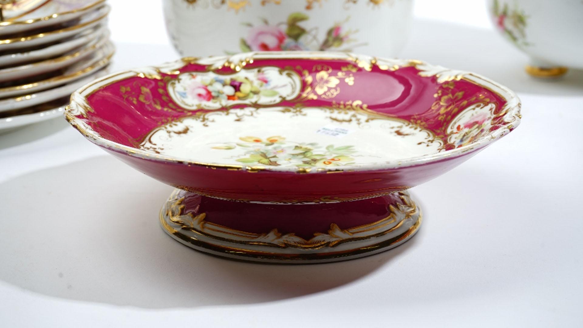 A Coalport porcelain dessert service, circa 1840s, each piece well painted with flower groups against a claret ground, this color depicting Royalty. Rims of plates have hand painted Cartouches that gives an elegant appearance.

The service