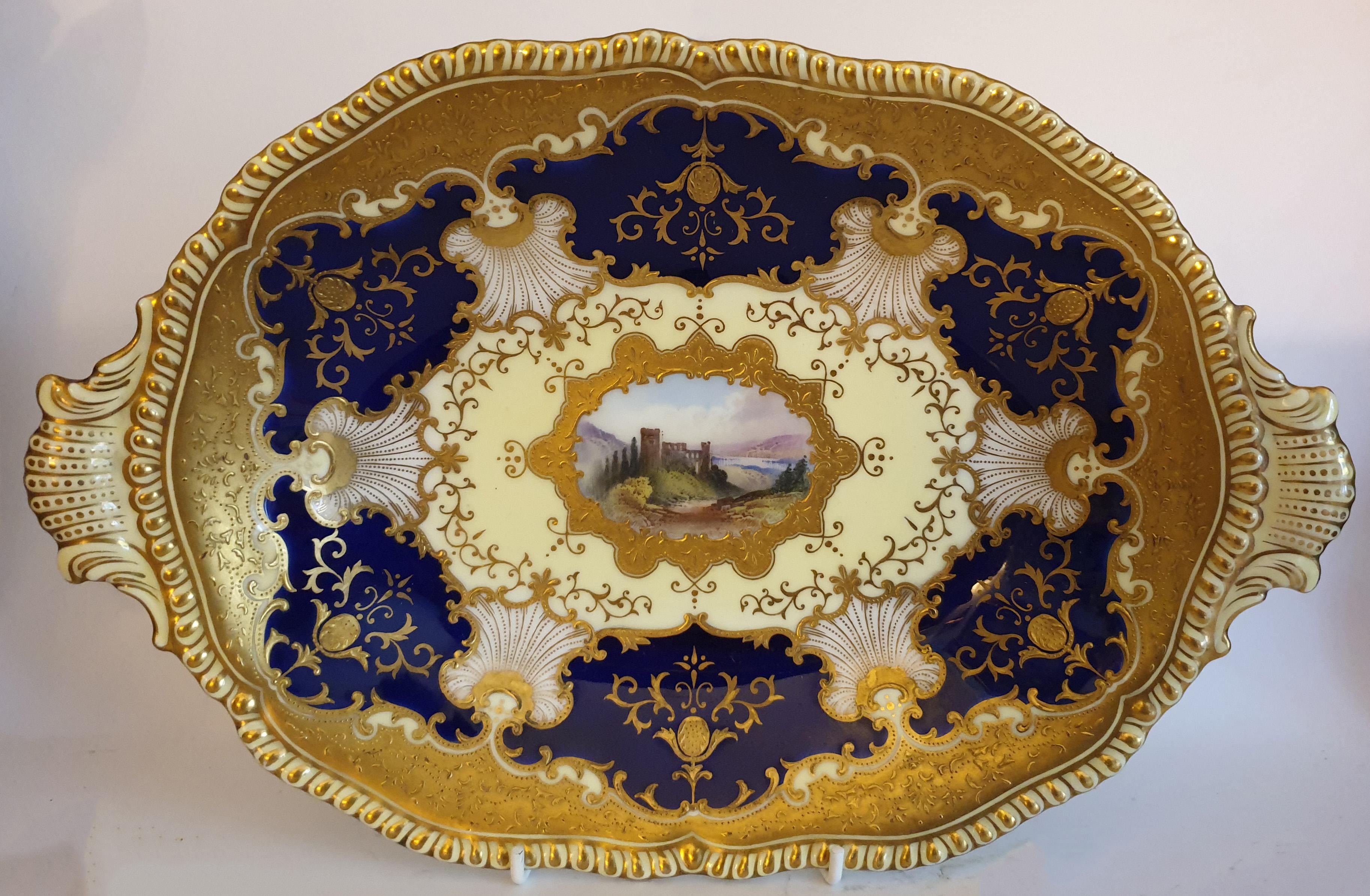 A rare Coalport Porcelain eight-piece dessert service, comprising a set of six dessert plates, an oval two handled serving dish and a square two handled serving dish. Each item is with an individual hand painted central cartouche; 'Loch Aw',