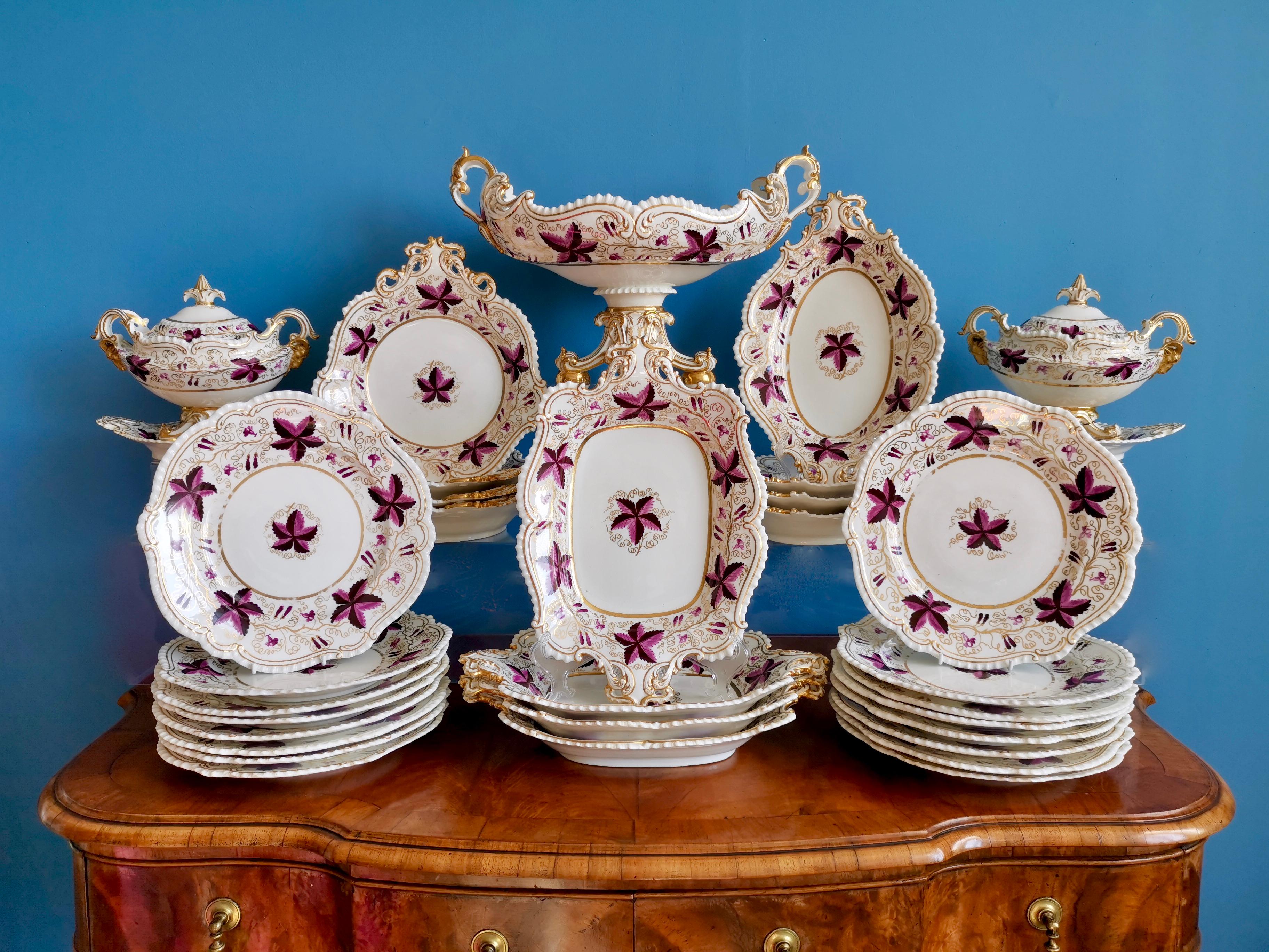 This is a rare and spectacular full dessert service made by Coalport around the year 1820. The service consists of a large footed comport or centre piece, two lidded sauce tureens on stands, four rectangular dishes, four oval dishes, four shell