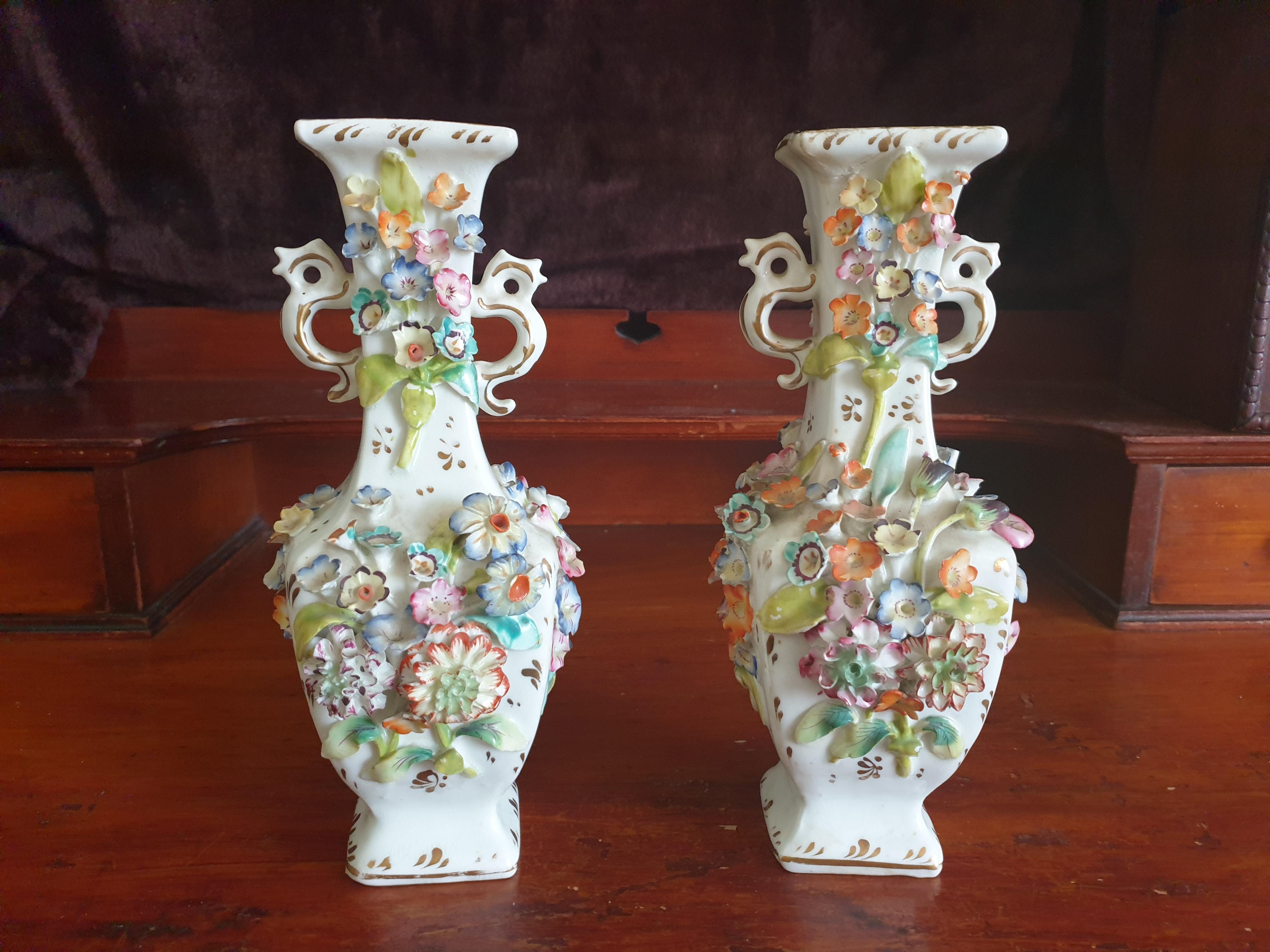 A stunning coalport pair of encrusted flower vases twin handled with a variety of flowers. Dates back early 19th century, generally in good condition however a few minor chips to the flowers that are not noticeable, comes with age. Overall condition