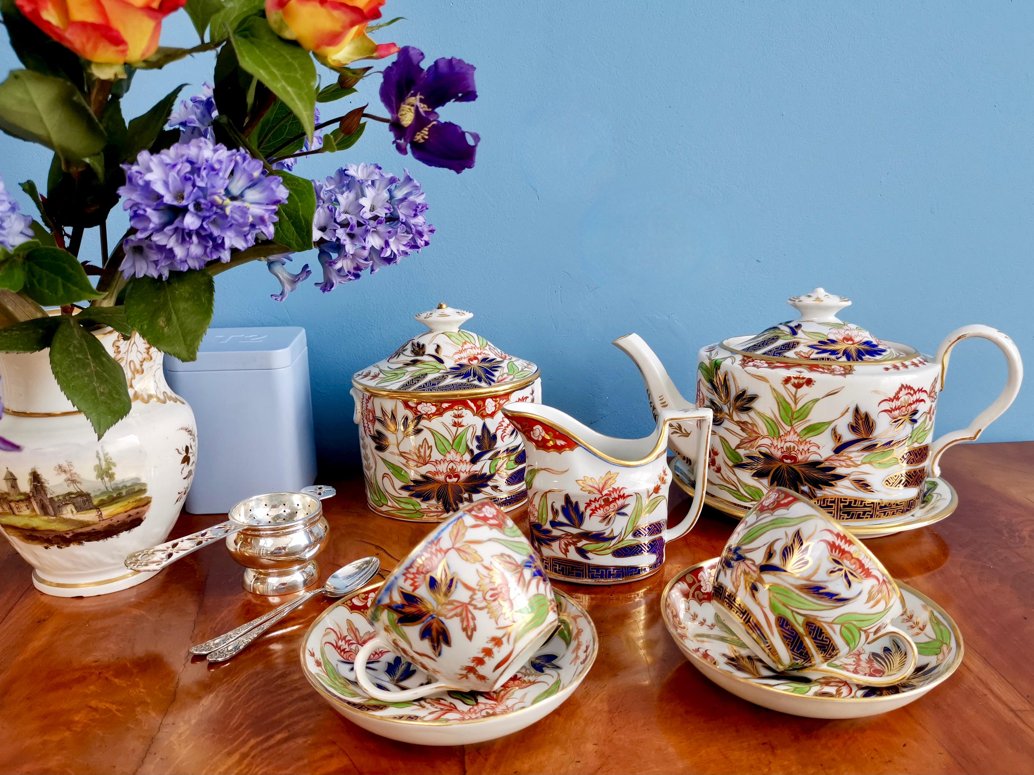 This is a beautiful breakfast tea service made by John Rose at Coalport between 1803 and 1807. It consists of a teapot with cover and stand, a sucrier with cover, a milk jug, and two teacups and saucers. The set is decorated with the very famous