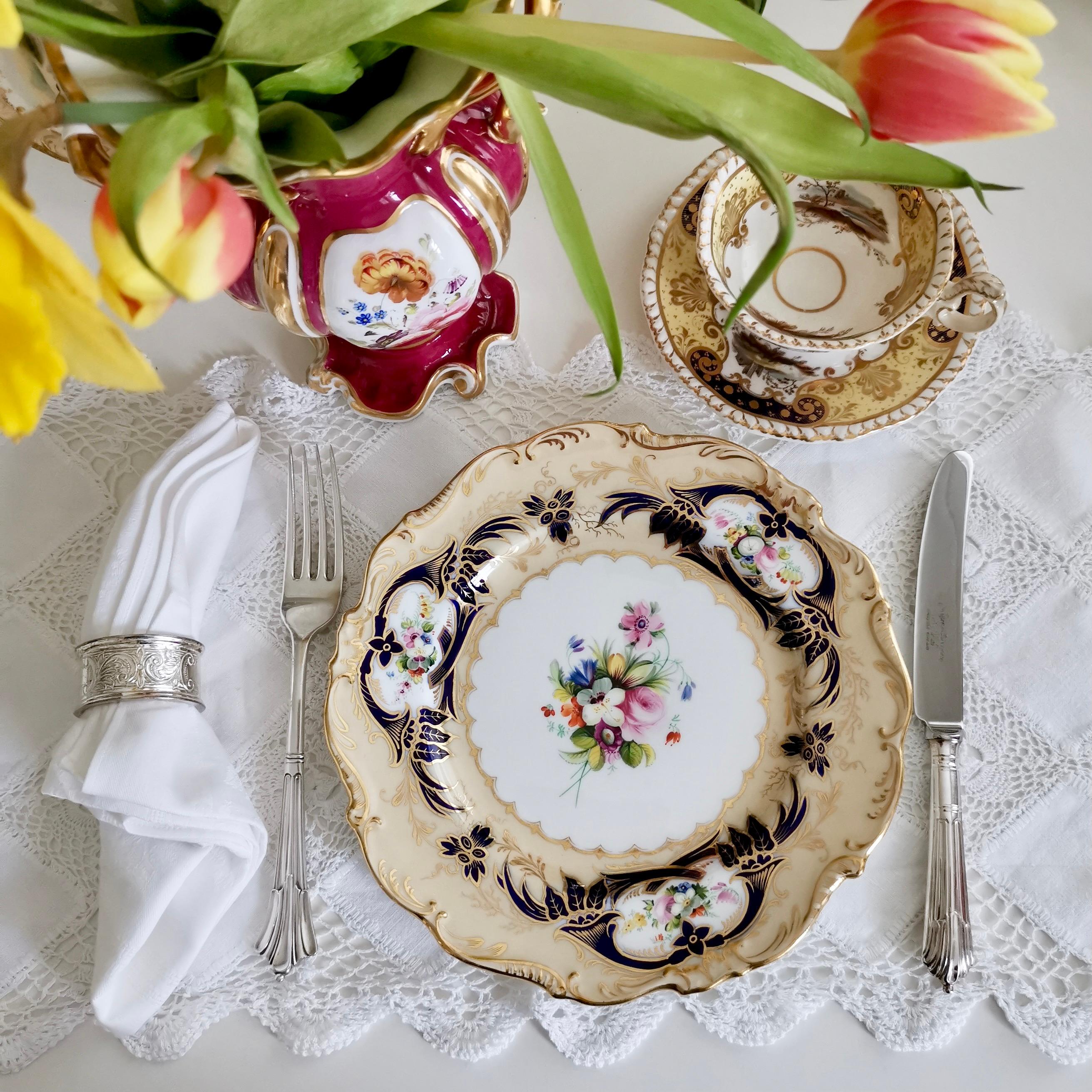 This is a beautiful dessert plate made by Coalport in about 1841. The plate has a simple scroll moulded rim, a beige and cobalt blue ground and beautiful flowers painted by Brindley.

Coalport was one of the leading potters in 19th and 20th