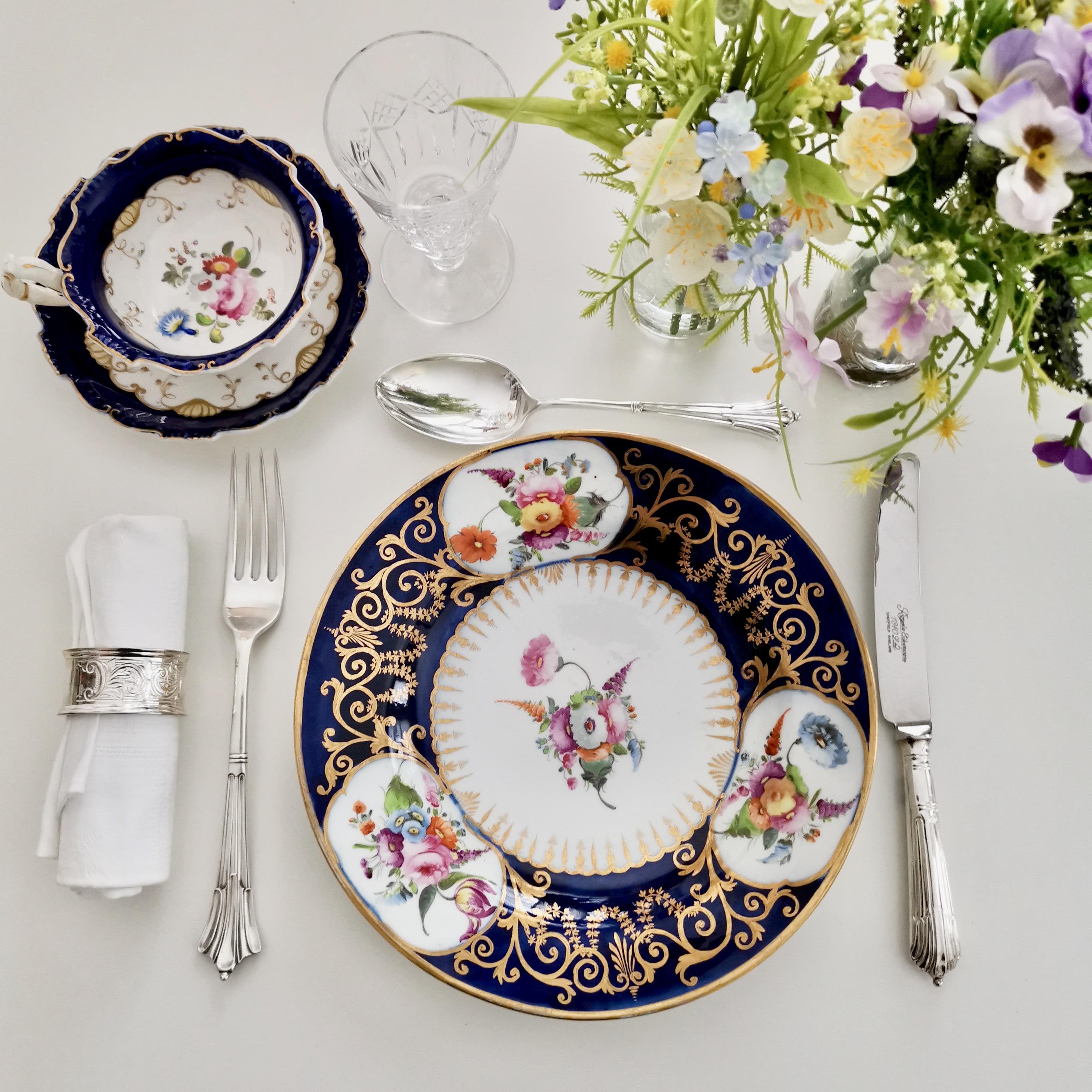 This is a very beautiful plate made by John Rose in Coalport in circa 1805 or 1810, which was the Georgian era. The plate has a beautiful cobalt blue ground, rich gilding and elegant hand painted floral reserves.

Coalport was one of the leading