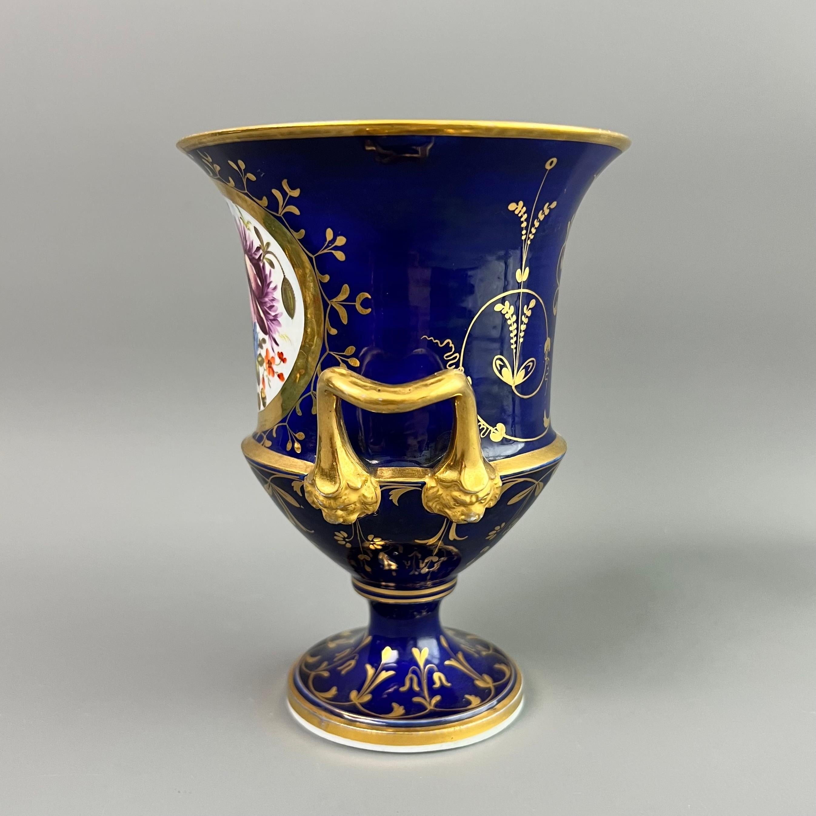 On offer is a sublime little porcelain campana vase made by Coalport in about 1815. The vase has a deep cobalt blue ground, beautiful gilding and a sublimely hand painted flower reserve.

Coalport was one of the leading potters in 19th and 20th