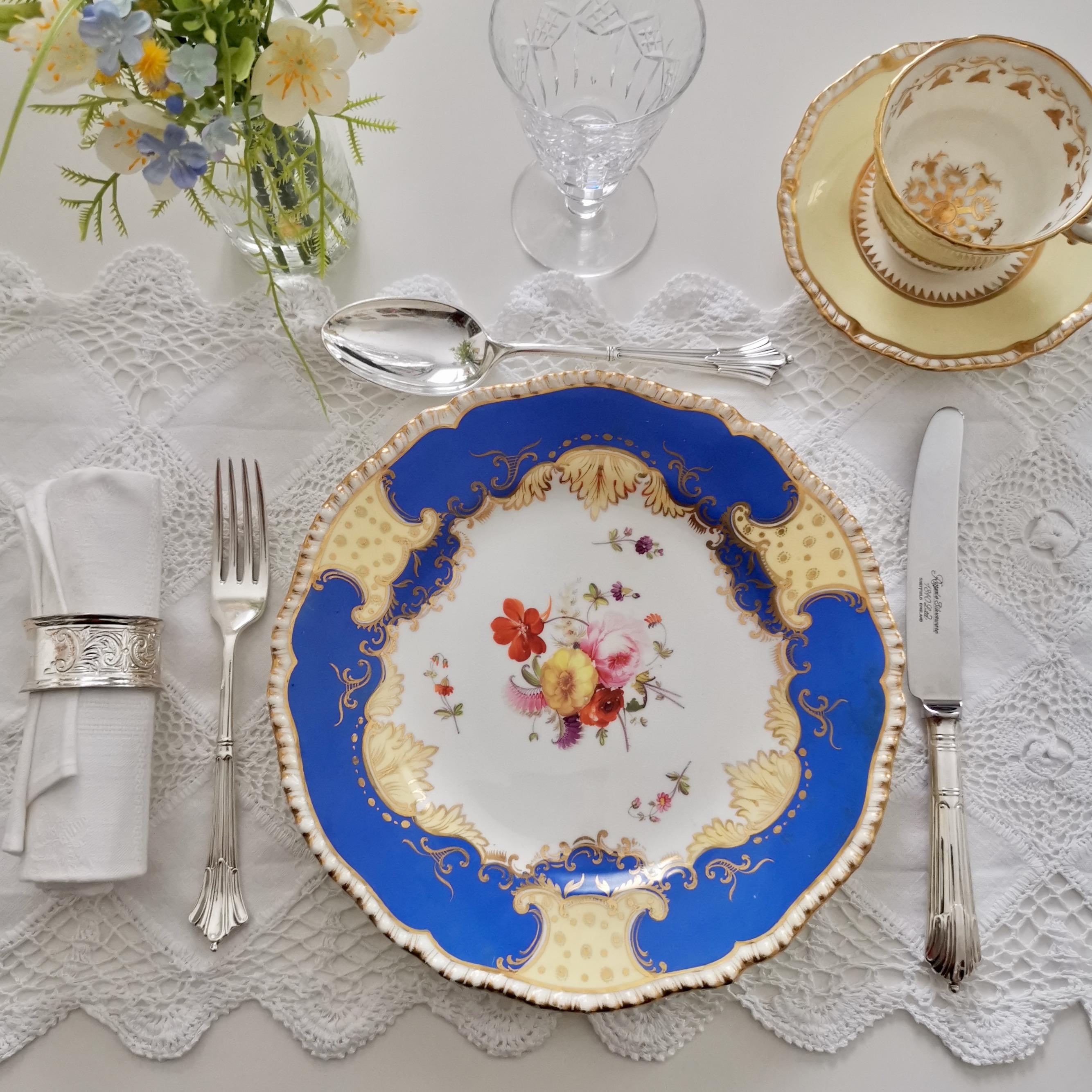 This is a beautiful dessert plate made by Coalport circa 1825, which was the Regency era. The plate has a beautifully gadrooned rim, a bright blue ground with pale yellow and gilt details and hand painted flowers in the centre.

Coalport was one