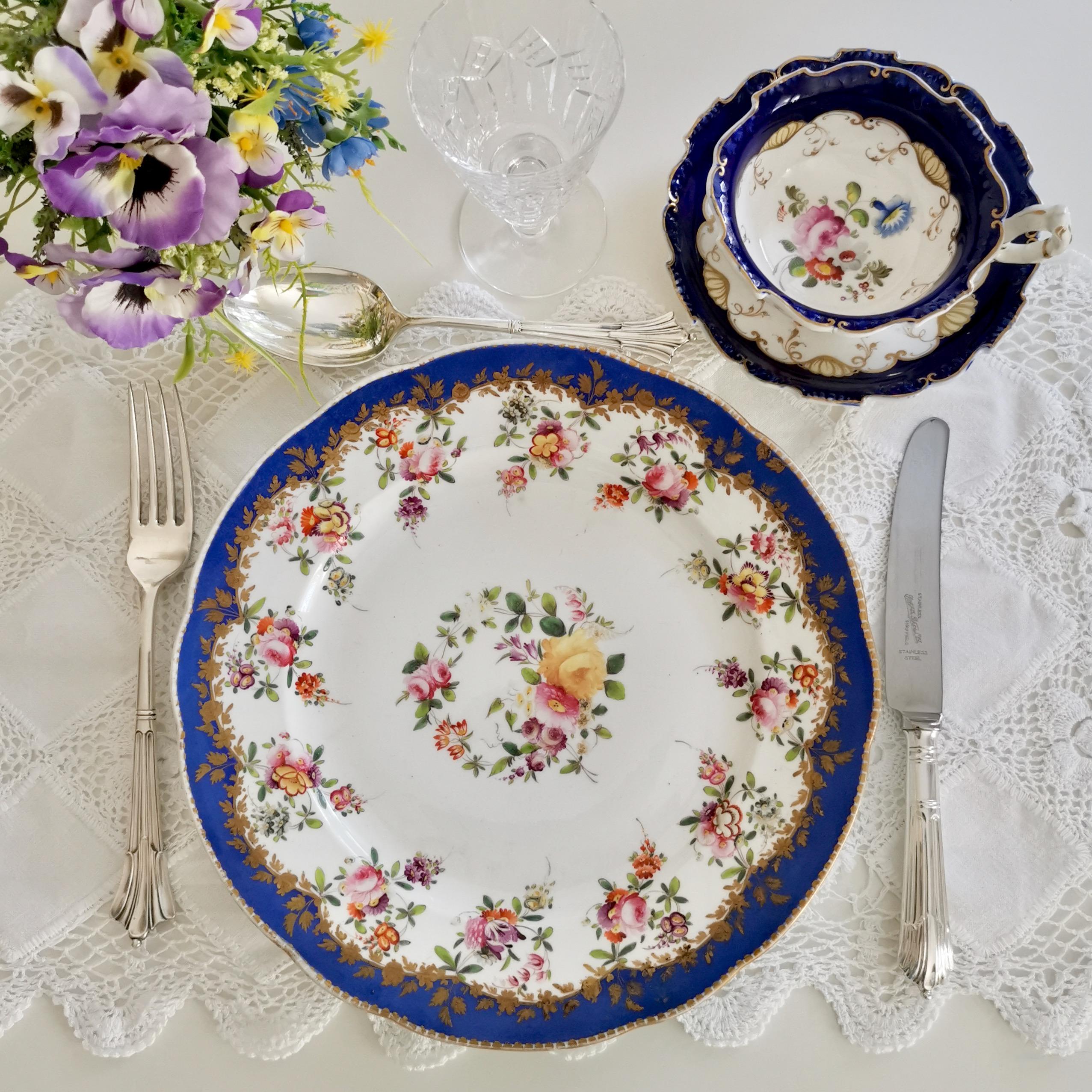 This is a beautiful large dinner plate made by Coalport some time between 1820 and 1825. The plate has a bright royal blue rim and finely hand painted flower garlands.

Coalport was one of the leading potters in 19th and 20th Century