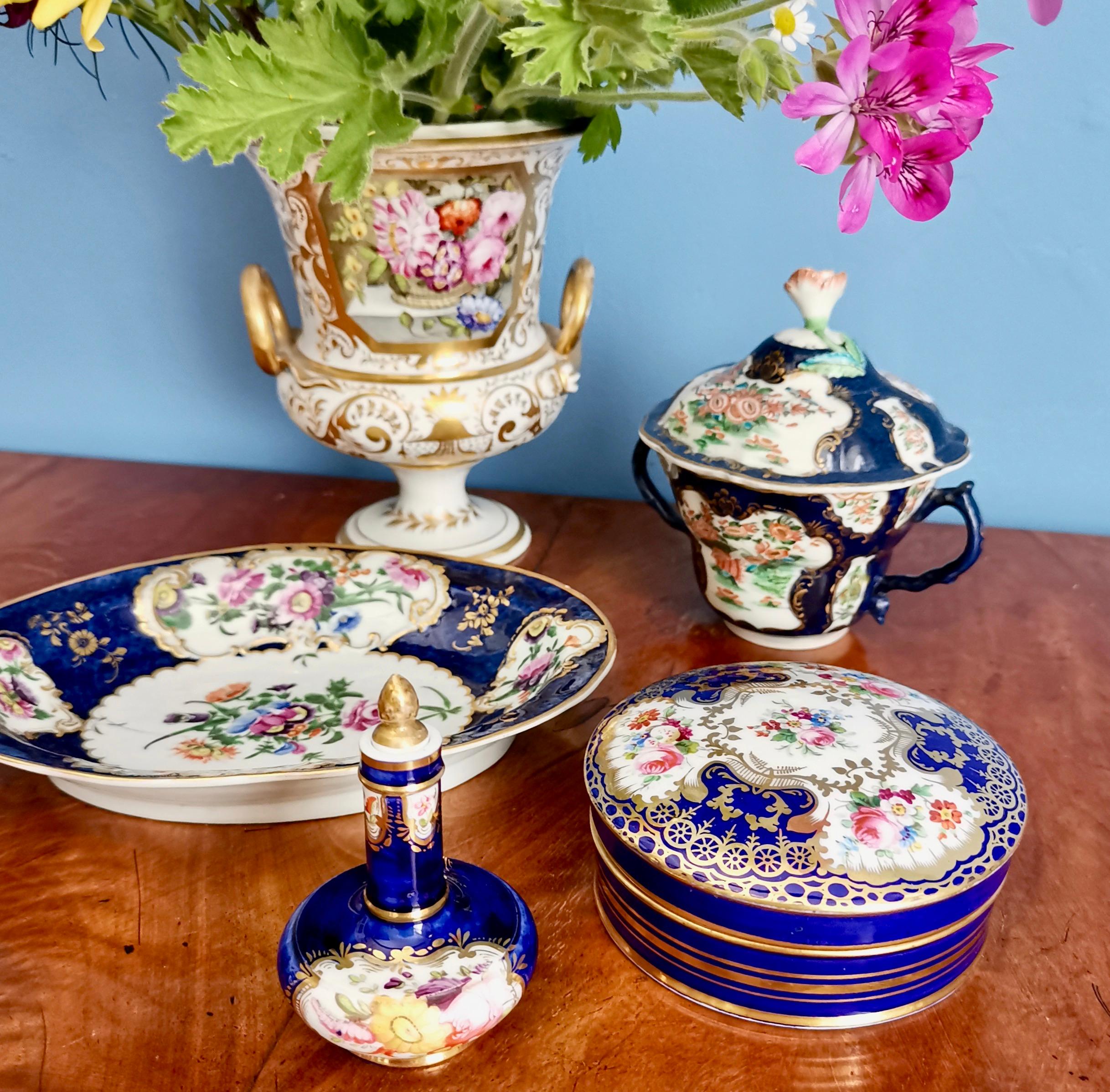 This is a beautiful porcelain scent bottle made by Coalport in circa 1820, which was the Regency era. The bottle has a deep cobalt blue ground with stunning flowers and gilding, and a gilded stopper.

Coalport was one of the leading potters in