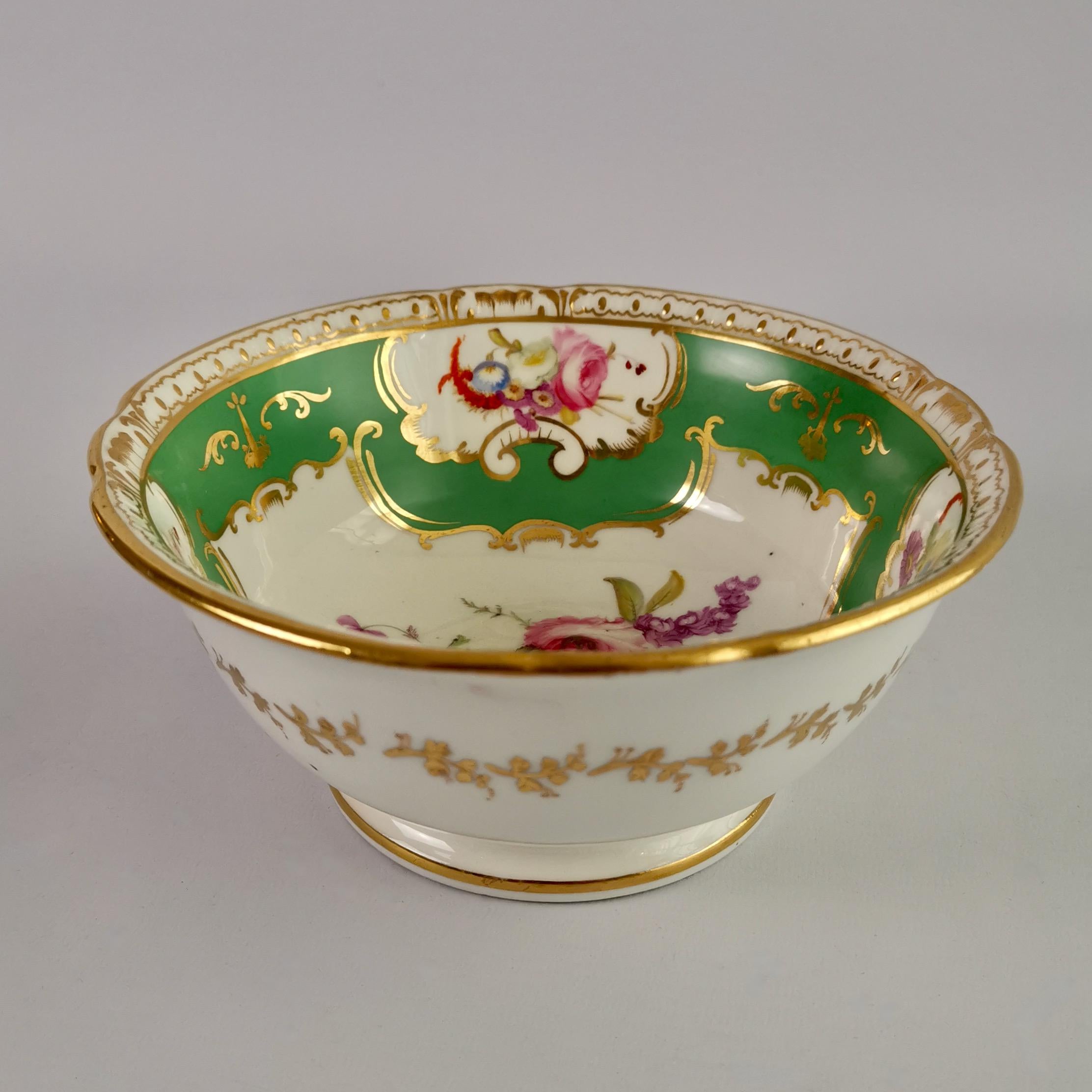 This is a beautiful slop bowl made by Coalport circa 1826, which was the late Regency era. The bowl has a bright green ground color with hand painted flower reserves and nice gilded moulding on the rim.

Coalport was one of the leading potters in