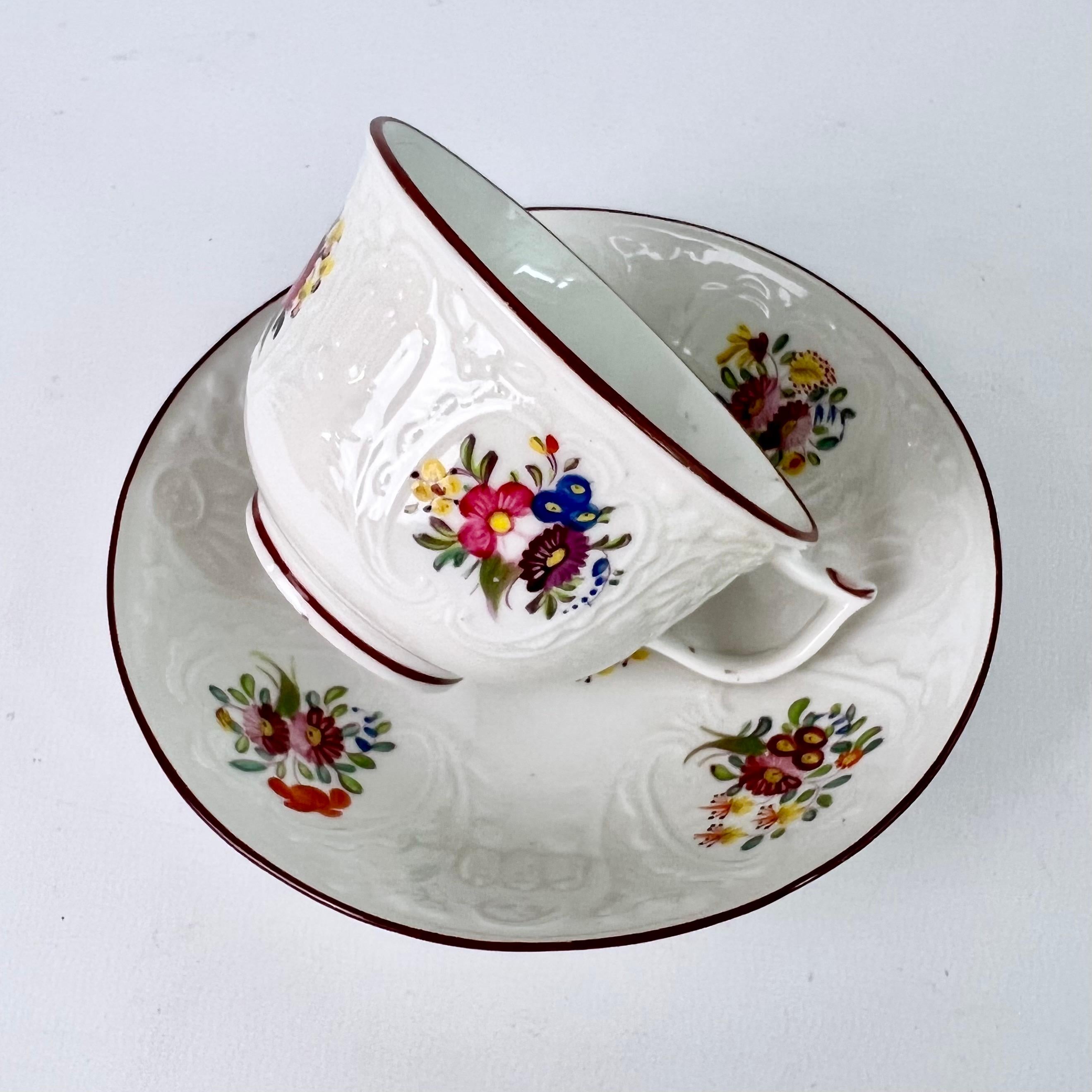 This is a beautiful teacup and saucer made by Coalport in about 1817. The teacup is blind-moulded in the 