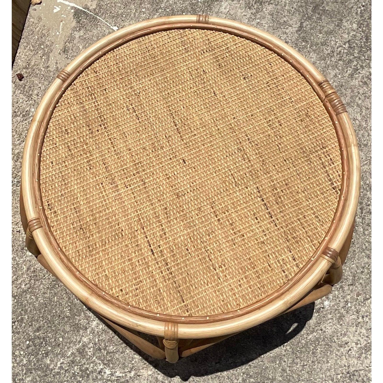 A gorgeous Coastal rattan coffee table. A beautiful design with bent rattan in big loops with a chic woven rattan top. Perfect for indoors or out. Acquired from a Miami estate.