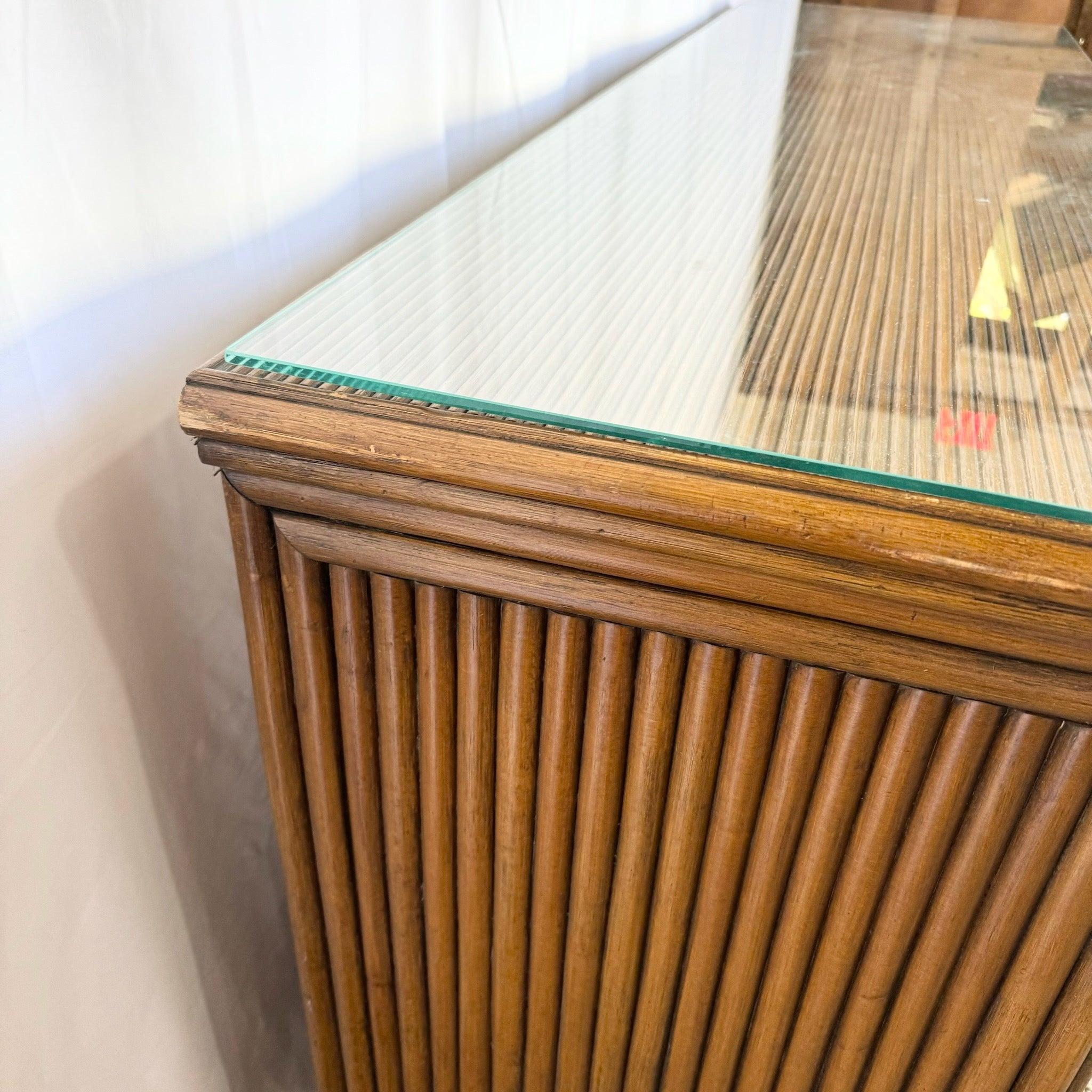 Comò in rattan Coastal Boho con piano in vetro, caratterizzato da una robusta struttura in rattan e dettagli intrecciati, perfetto per aggiungere eleganza agli interni coastal o bohémien.
 
 Alcuni segni di usura sulla finitura, come mostrato nelle