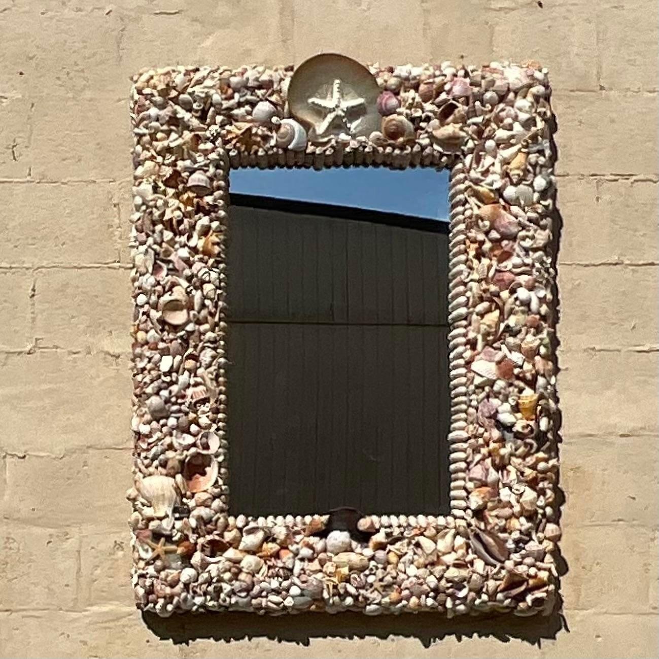 A fantastic vintage Coastal wall mirror. A hand made creating using the most gorgeous vintage shells. Acquired from a Palm Beach estate.
