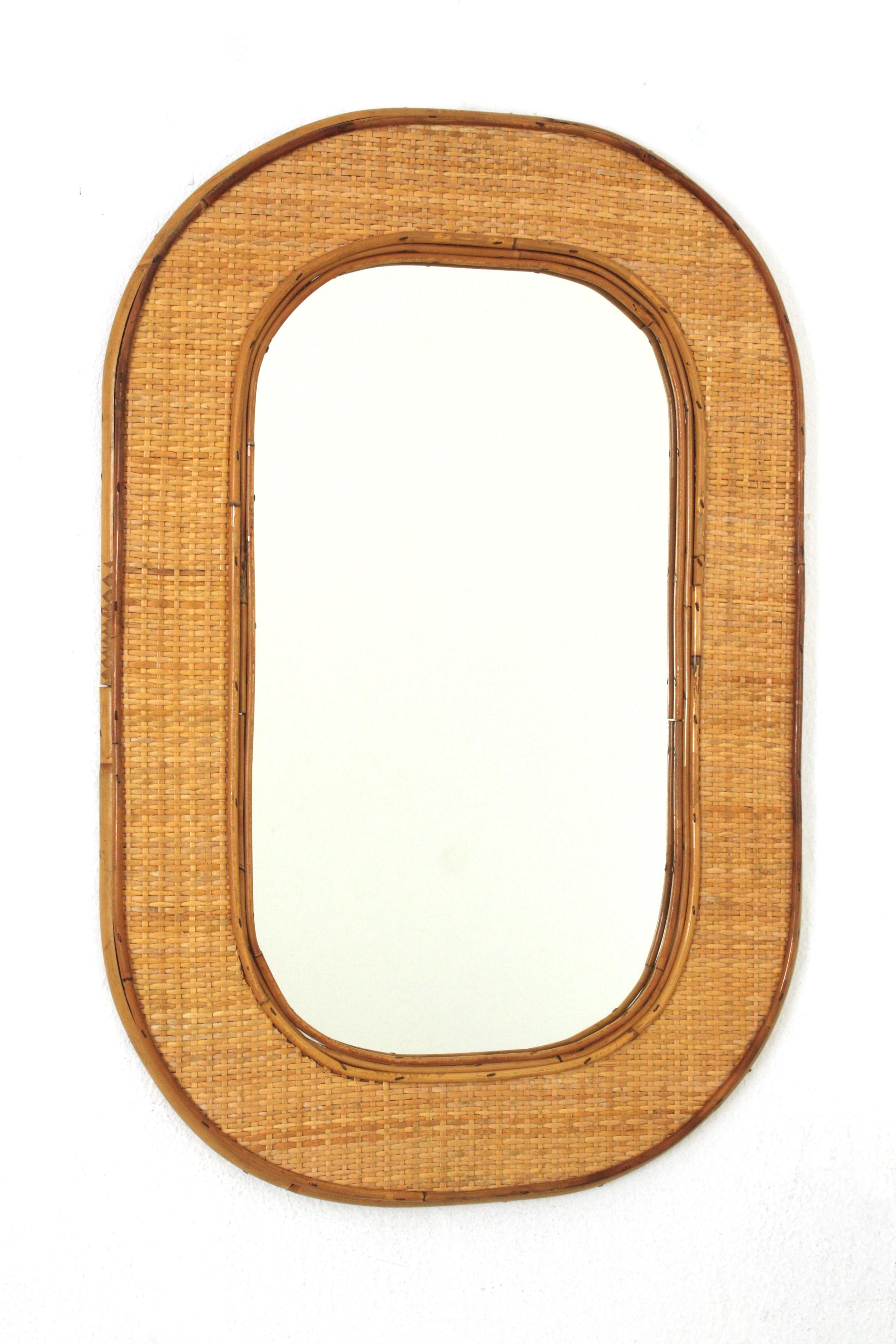 Italienische Riviera Ovaler Spiegel aus Rattan und Weide, Italien, 1960-1970.
Elegantes ovales Korbgeflecht aus der Mitte des 20. Jahrhunderts mit Bambus-Rattan-Rahmen. Sie erinnert an die Entwürfe von Gabriella Crespi und der Christian Dior Home