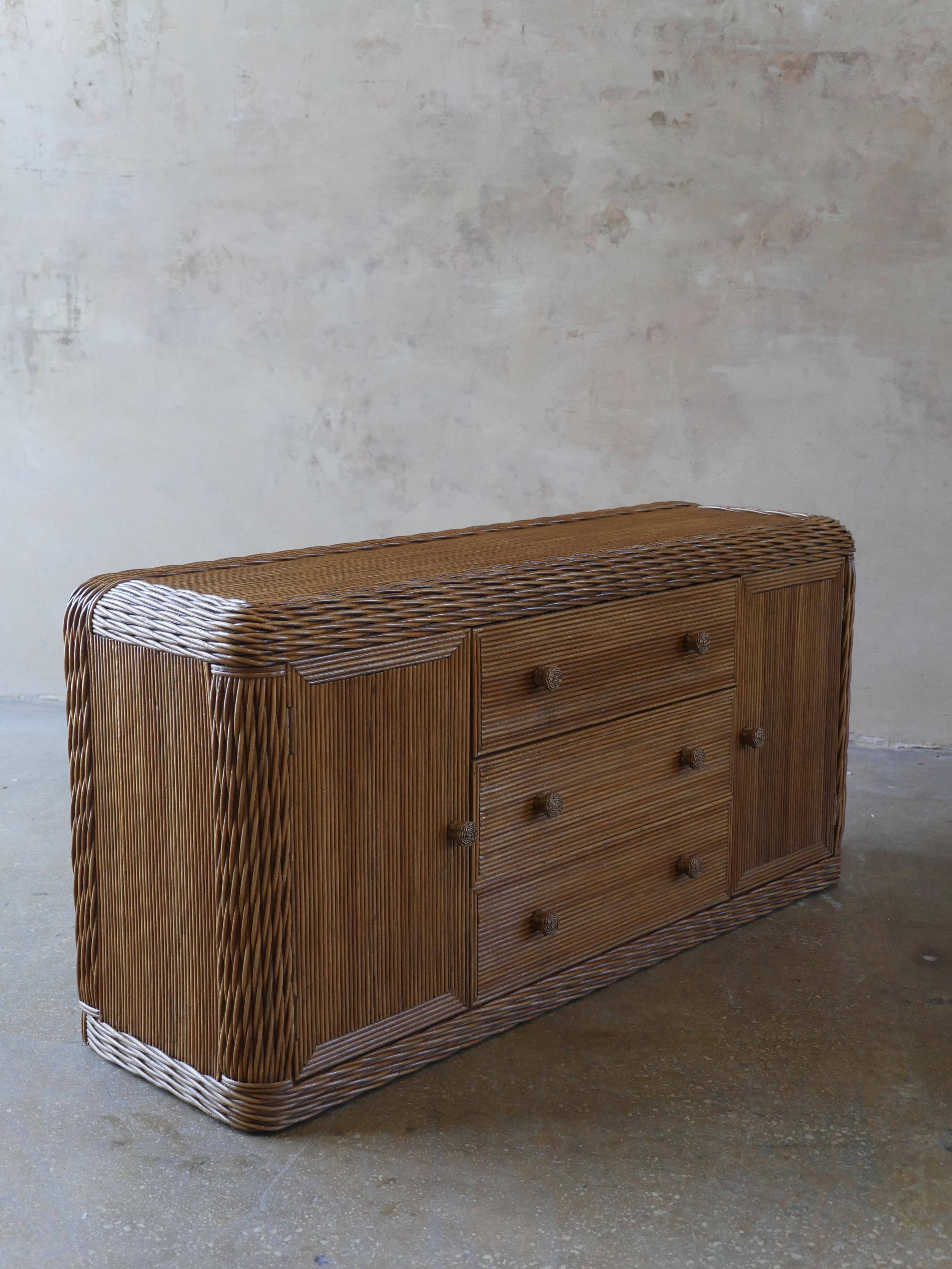 Beautiful coastal, braided wicker and pencil reed rattan credenza. The intricately designed credenza adds a nice touch of warmth and boho chic style to any space.