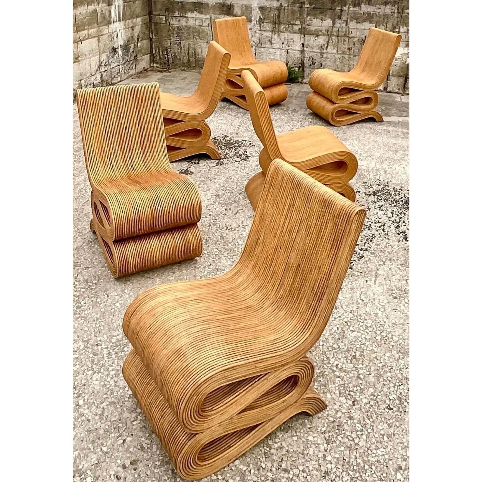 Fabulous Coastal Pencil Reed dining chairs. The iconic “wiggle Chair” design in a chic honey color. Sold in pairs with three sets available. Acquired from a Miami estate.