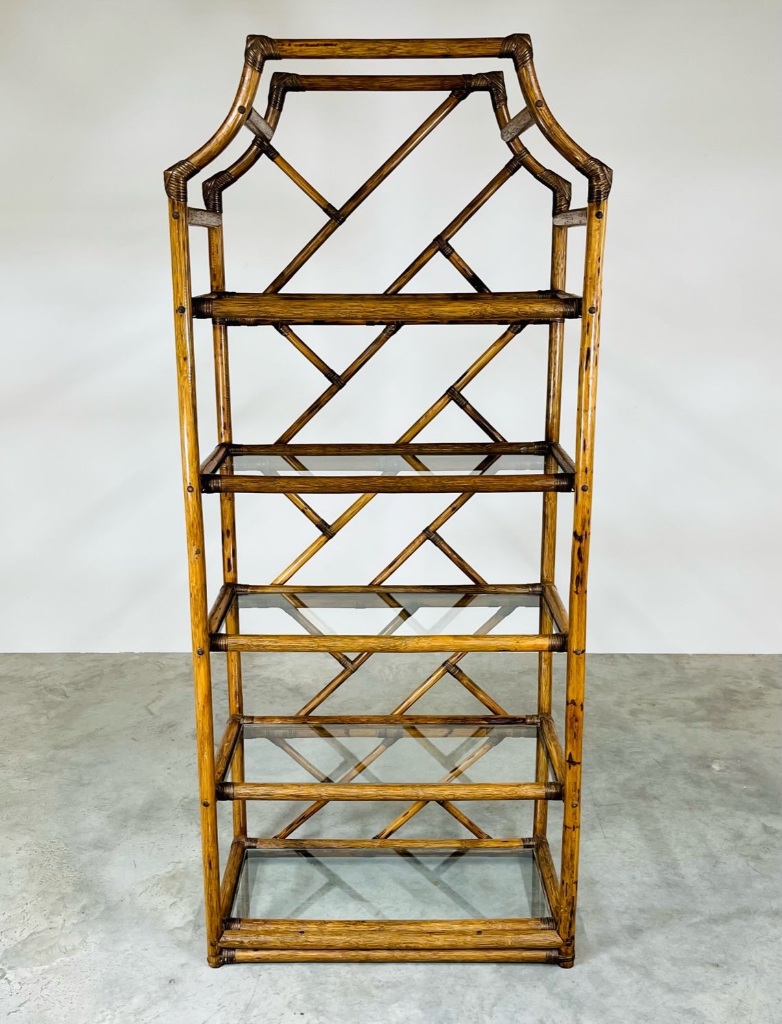 Beautiful Coastal rattan Chippendale glass shelf bamboo etagere having cane joinery with five glass shelves in outstanding condition. Perfect storage for books and collectibles. 
All glass is in great condition as well as the entire bamboo and cane