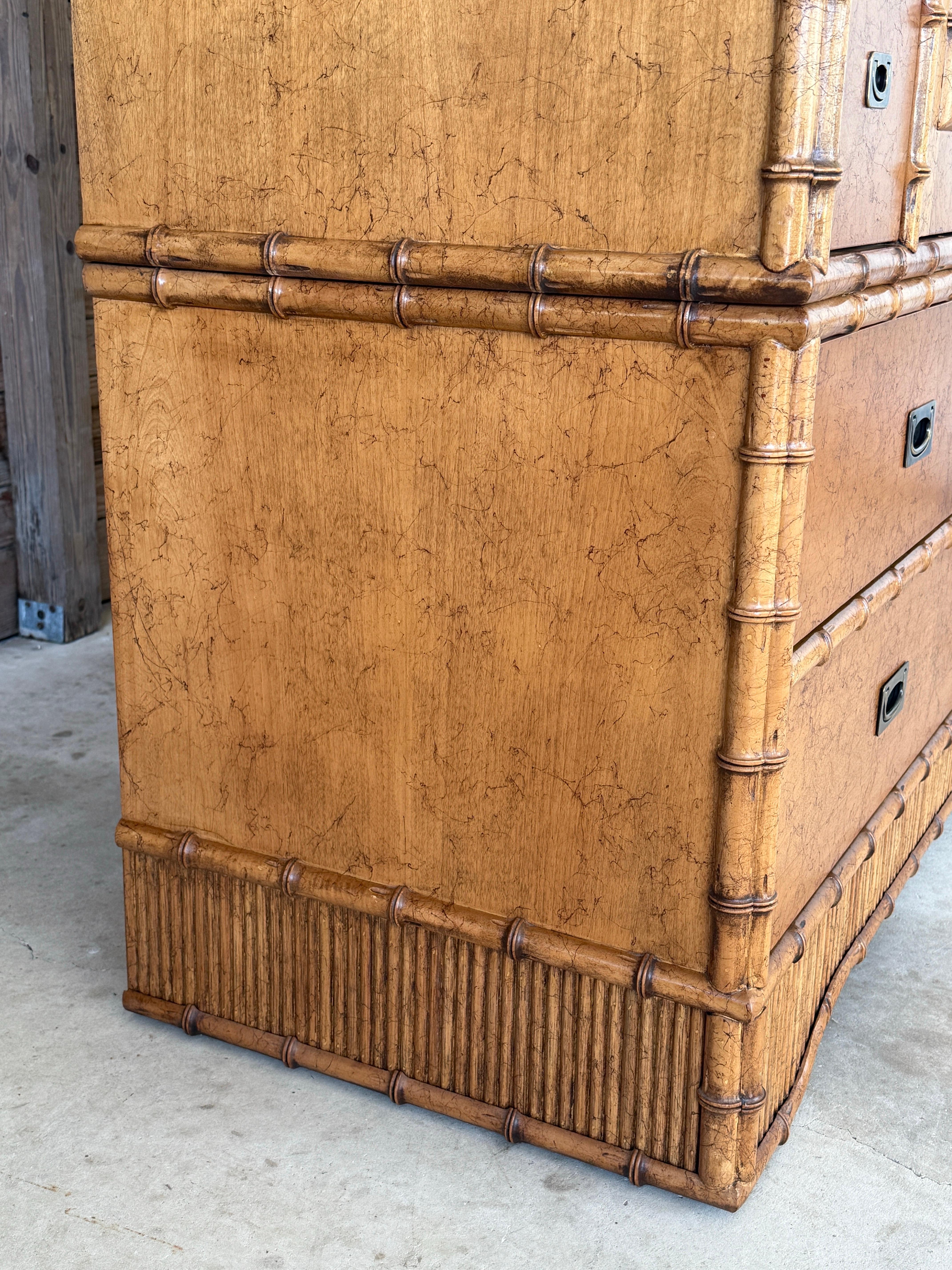 A striking 1980s two-piece armoire designed by Miller Yee Fong for Ficks Reed, showcasing faux bamboo trim and cane panel insets.
This substantial piece features pocket doors that open to reveal interior shelving and ample storage, along with four