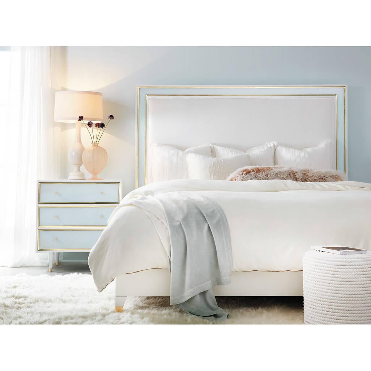 Coastal Sea Glass Bed. The wooden frame is lacquered in brilliant white with the headboard inset with Sea Glass foam color acrylic and framed in brass trim. Raised on tapered legs.

US King Dimensions: 81