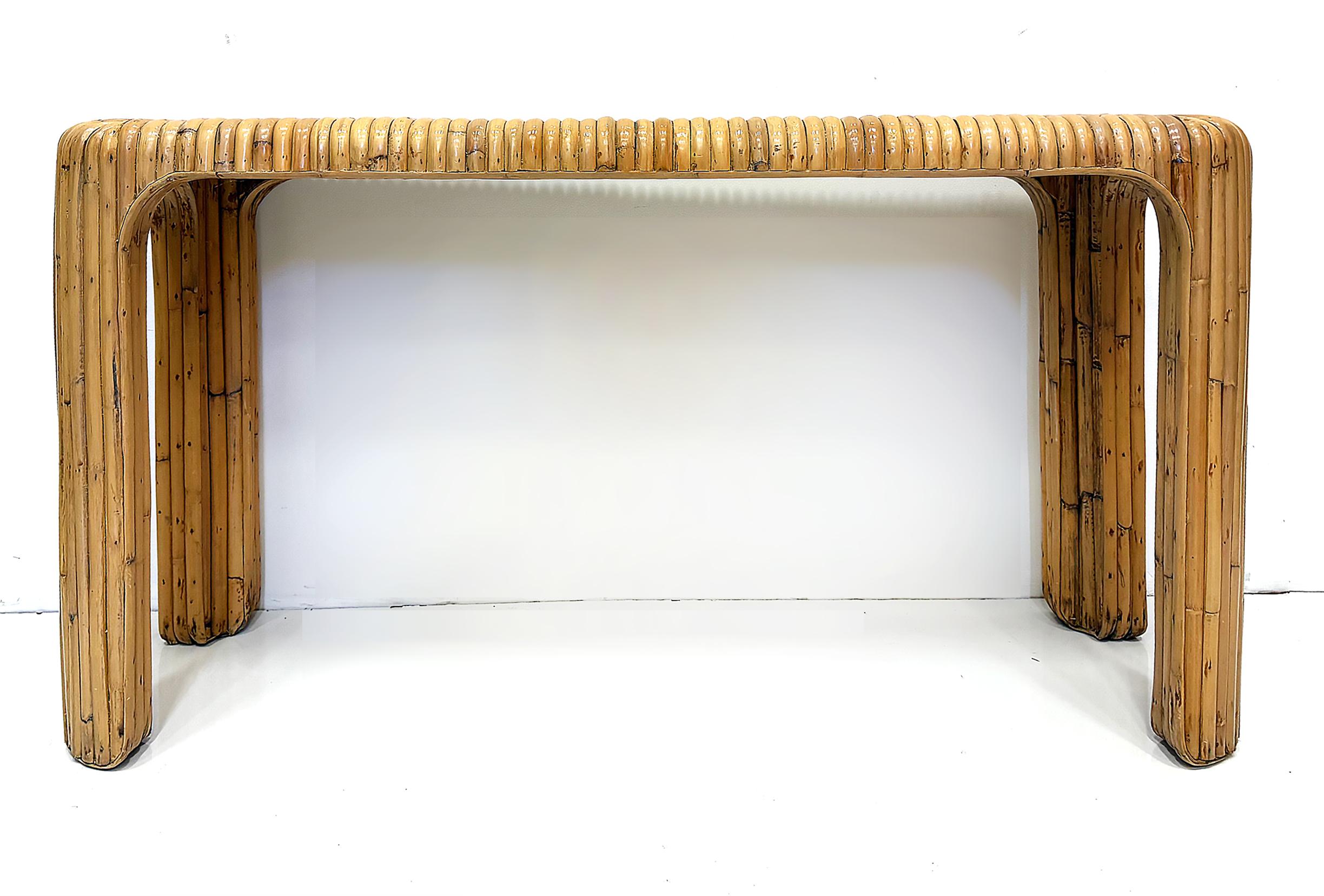 Coastal Split Reed Console Sofa Table with Waterfall Edges

Offered for sale is a vintage Costal split reed console or sofa table with edges that curve in the waterfall style. The table is clad with impressive large-scale split reed that is mitered
