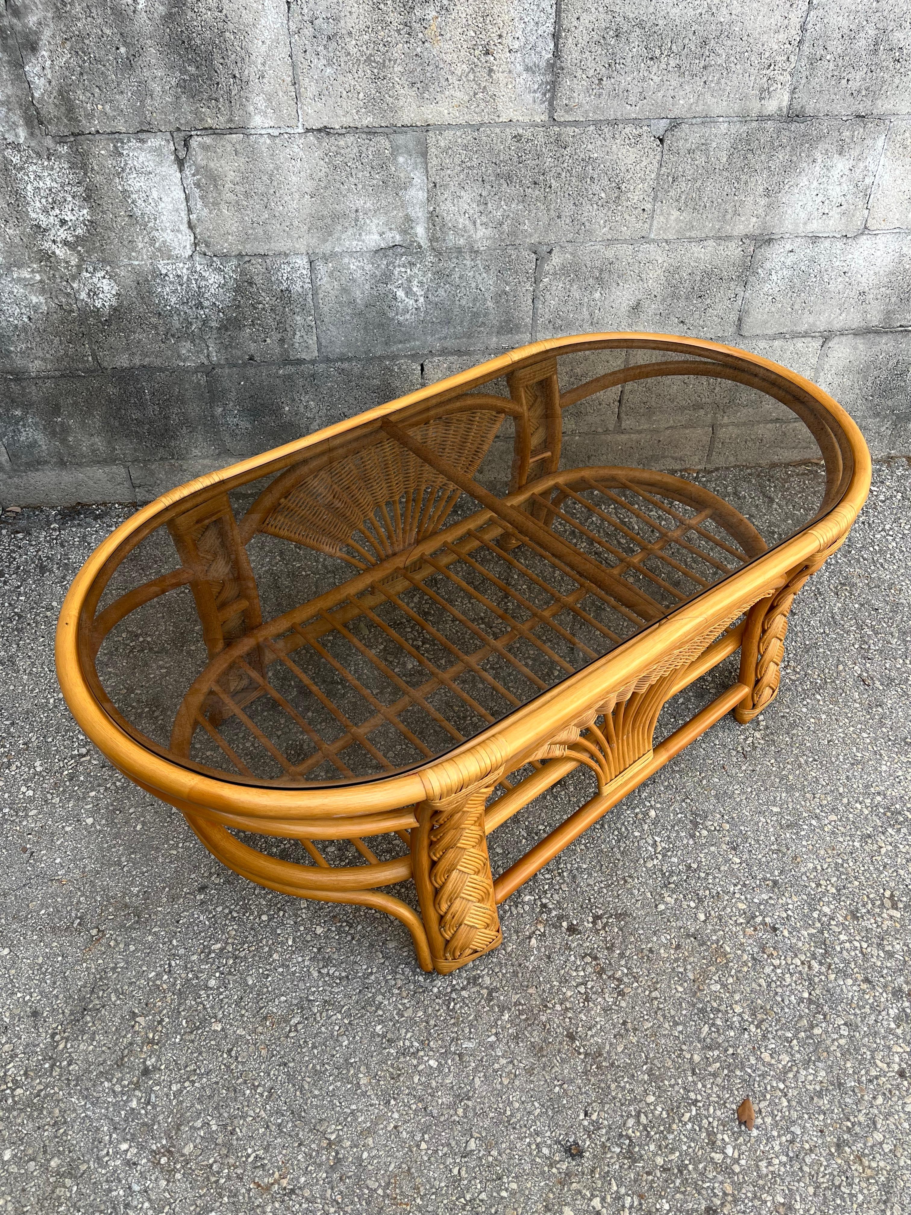 Table basse vintage en rotin tressé et osier de style côtier/bohème. Circa 1980
Il présente une forme ovale avec des garnitures en rotin tressé, un verre à fumée ovale amovible et un niveau intermédiaire pour un porte-revues supplémentaire.
En
