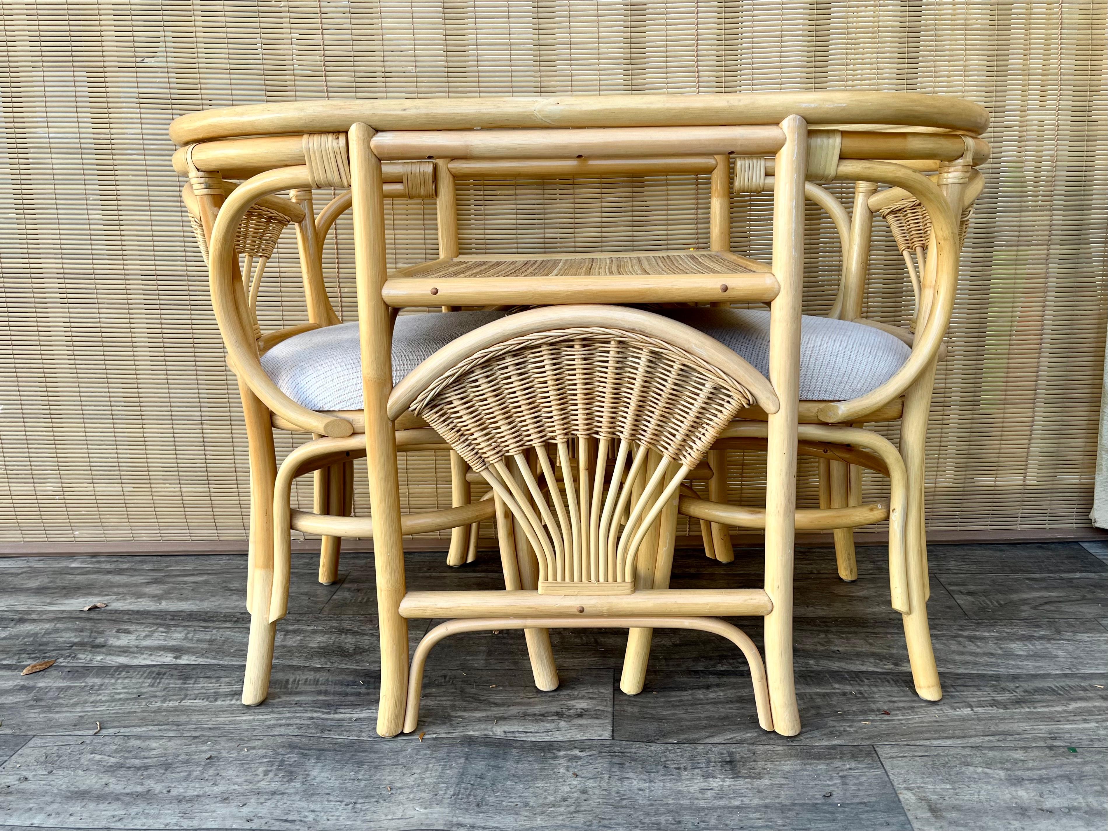 Vintage Coastal Style Natural Color Rattan and Wicker Two Seat Breakfast /Dinette Set. C 1980s
This adorable and functional dinette set features an oval table with a removable glass top and two chairs that slide under the table for easy storage.
In