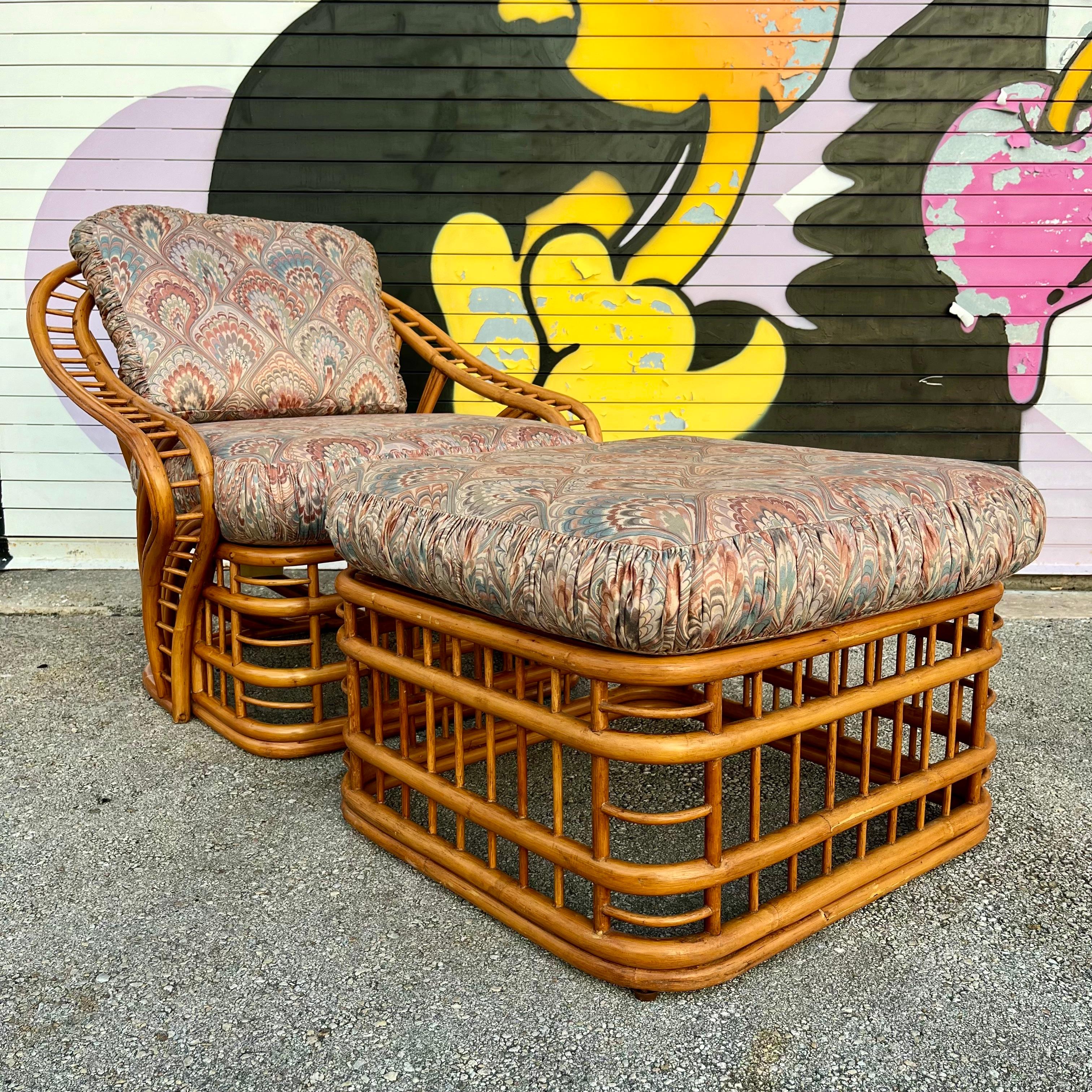Vintage Coastal Style Rattan Lounge Chair and Ottoman Set by Whitecraft Rattan Inc, Miami FL. Circa 1970s
Features a bent rattan frame with an intricate and dynamic fluid design at the back and armrests. 
In excellent original condition with very