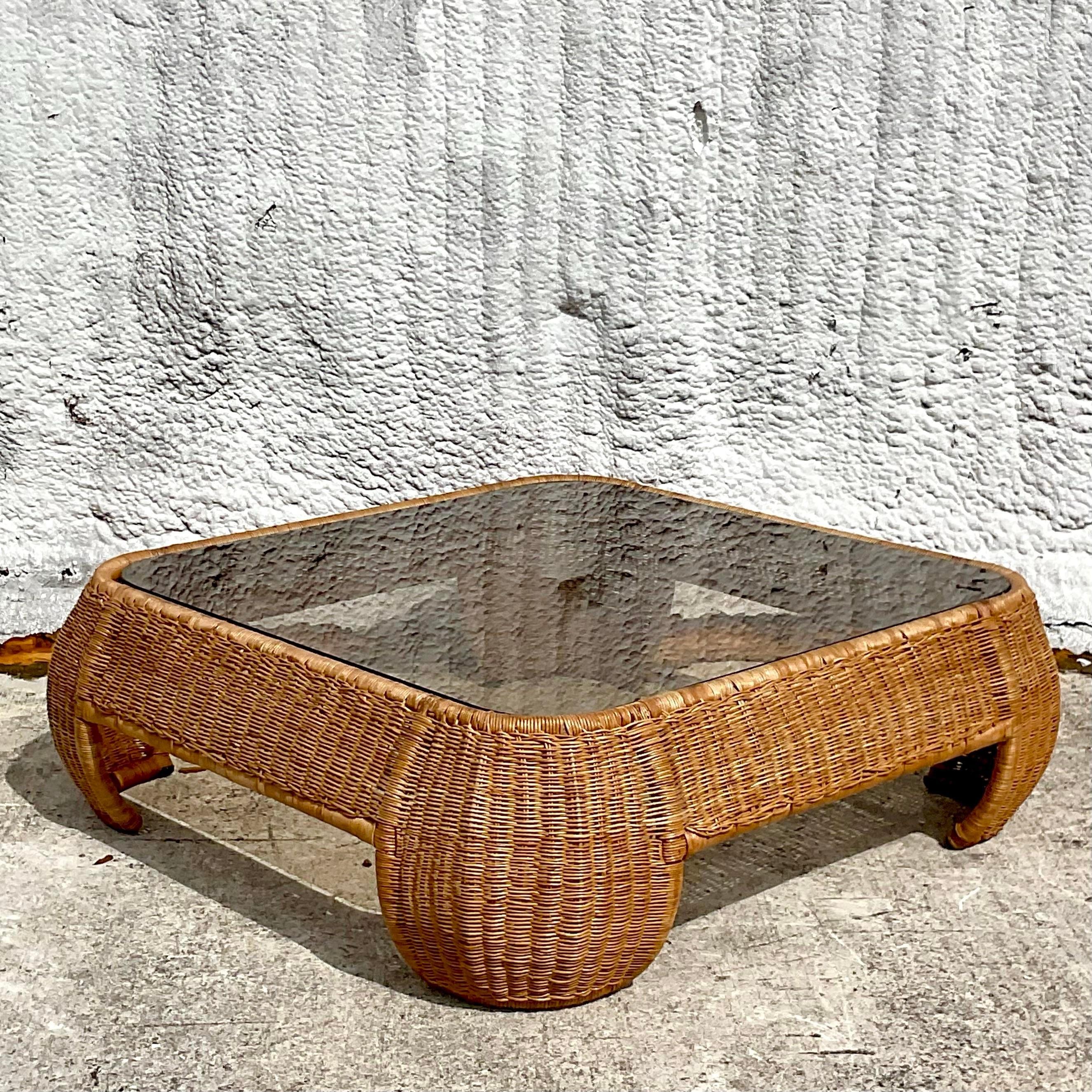 Infuse your living space with coastal elegance through this vintage woven rattan coffee table. Inspired by the relaxed vibes of American coastal living, its intricate design adds a touch of natural beauty and warmth to any room. Perfect for