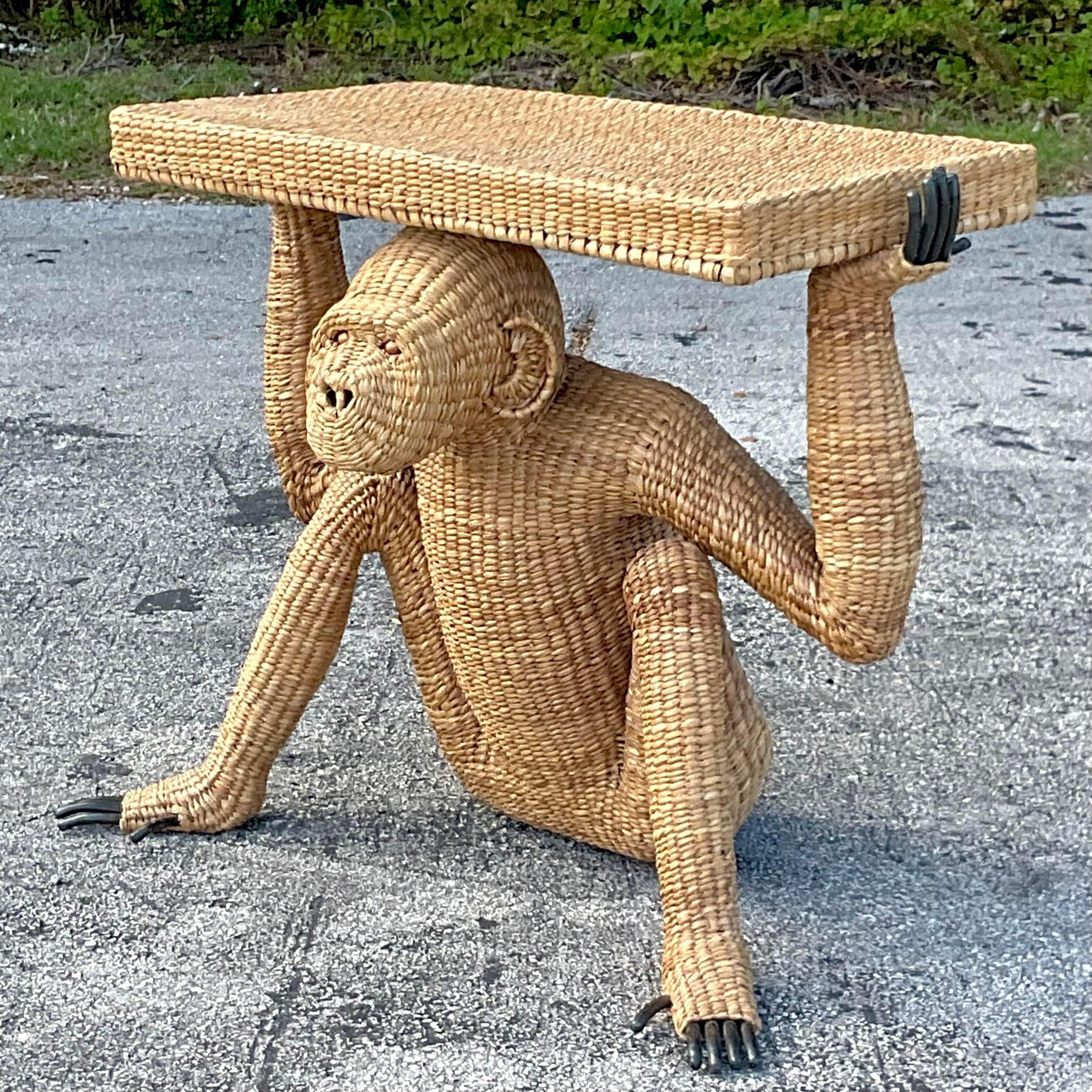 An exceptional vintage Coastal woven rattan console. Made by the iconic Mario Lopez Torres and tagged on the back. A charming little monkey holding up the table. Acquired from a Miami estate. 