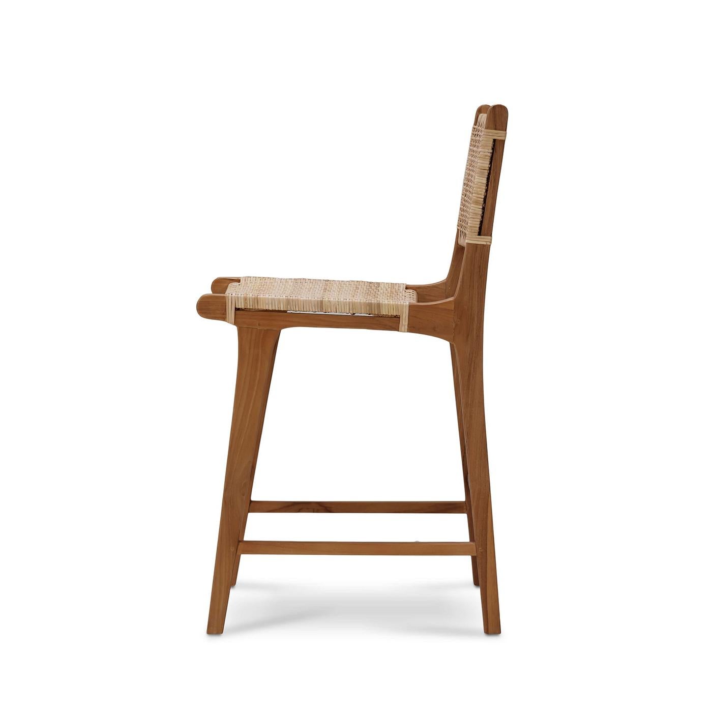 Una miscela armoniosa di charme costiero ed eleganza moderna. Questo sgabello da bar presenta una robusta struttura in legno di teak con finitura naturale, che garantisce durata e stile senza tempo. La seduta e lo schienale sono realizzati in rattan
