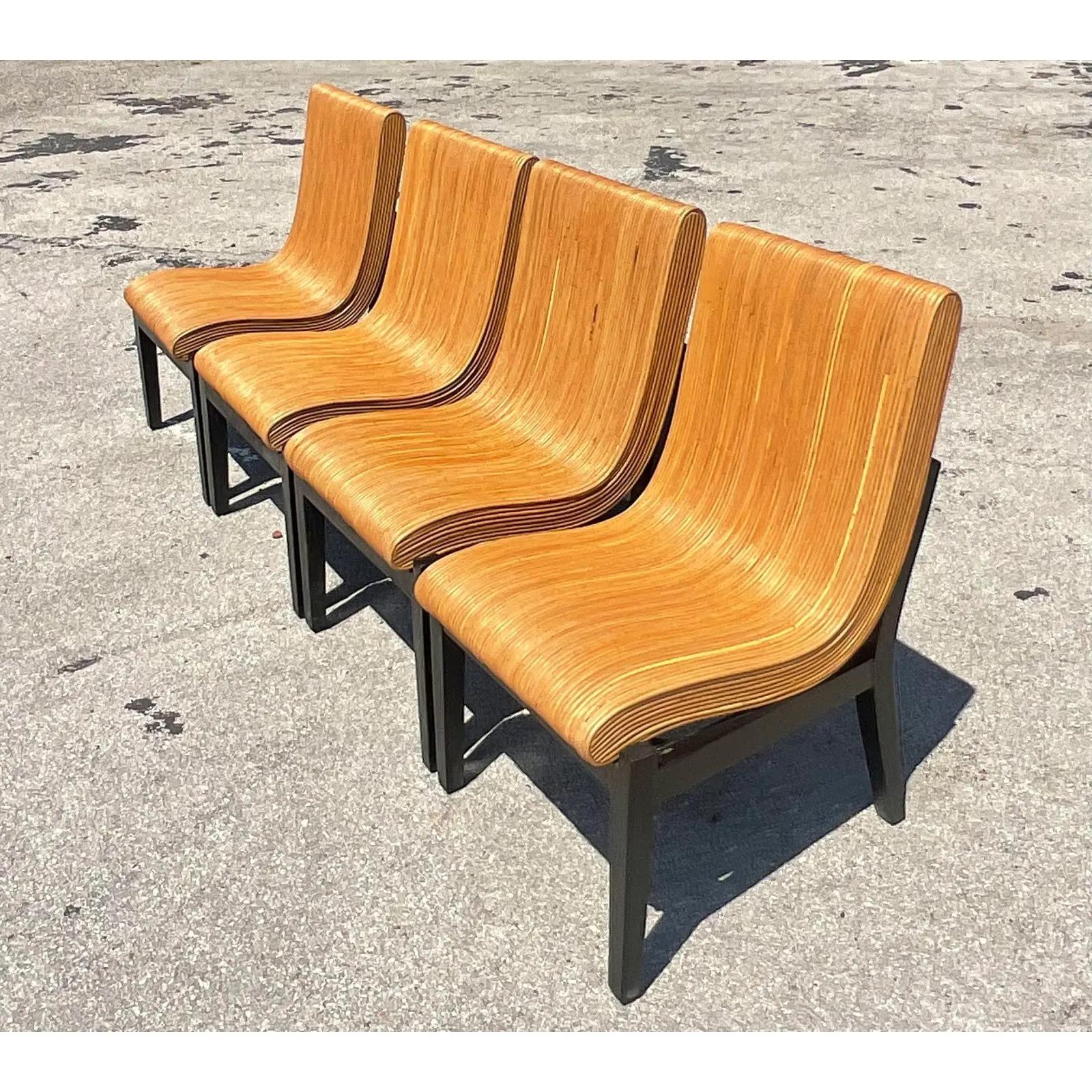 Fantastic set of four Coastal dining chairs. Beautiful pencil reed in a chic swoop design. The chair rest is in a contemporary wooden frame. Acquired from a Palm Beach estate.