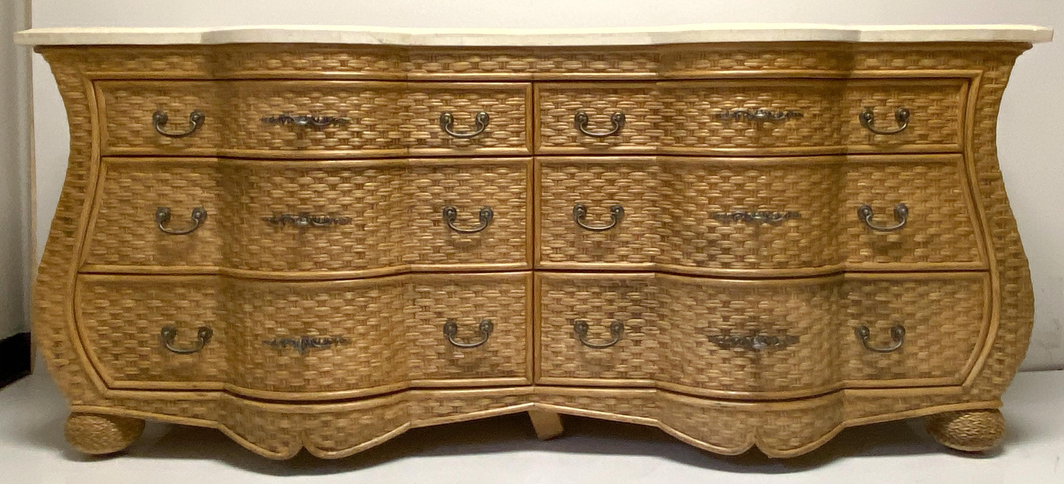 This is a wicker serpentine chest by WhiteCraft for Woodard. It has a travertine top that is not affixed to the piece. Note the fun wicker bun feet!.