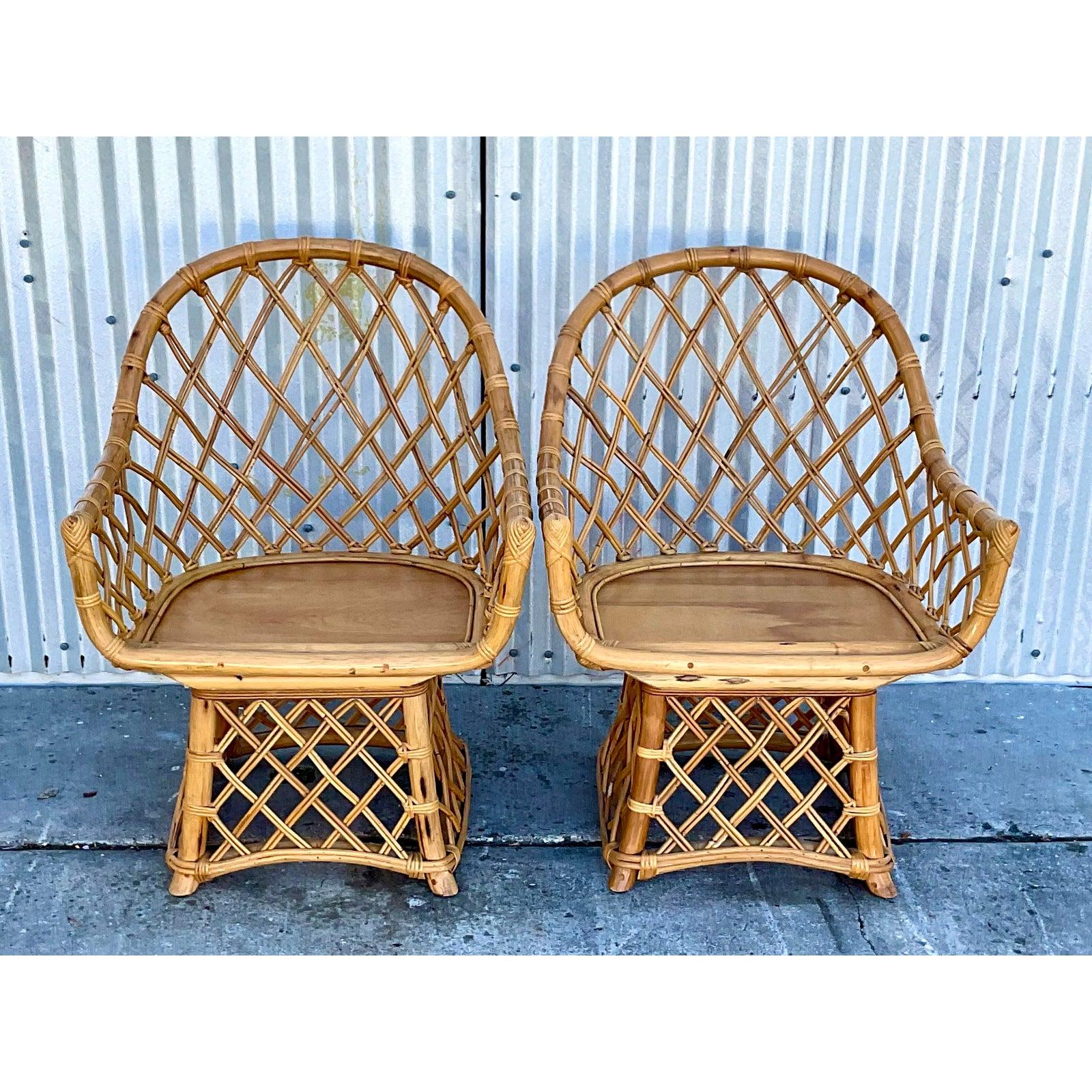 Stunning pair of vintage Coastal swivel chairs. Iconic wrap around rattan fretwork made famous by Willow and Reed. Unmarked. Acquired from a Palm Beach estate.