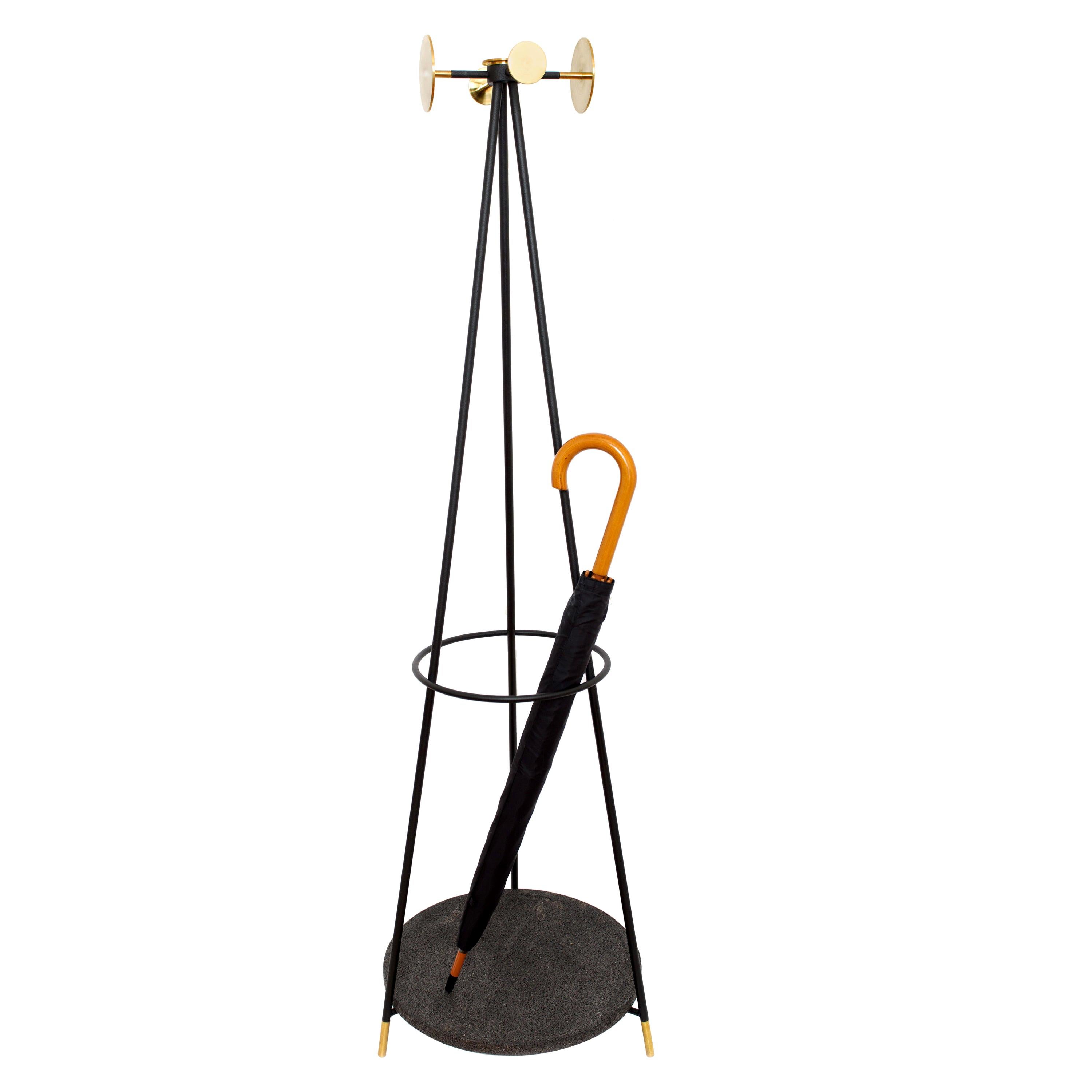 The function of the hand carved lava stone dish at the bottom is to absorb rainwater from recently used umbrellas. The hooks and gold details of this coat stand are made of turned brass and the rest is made of powder-coated metal bar in black. This