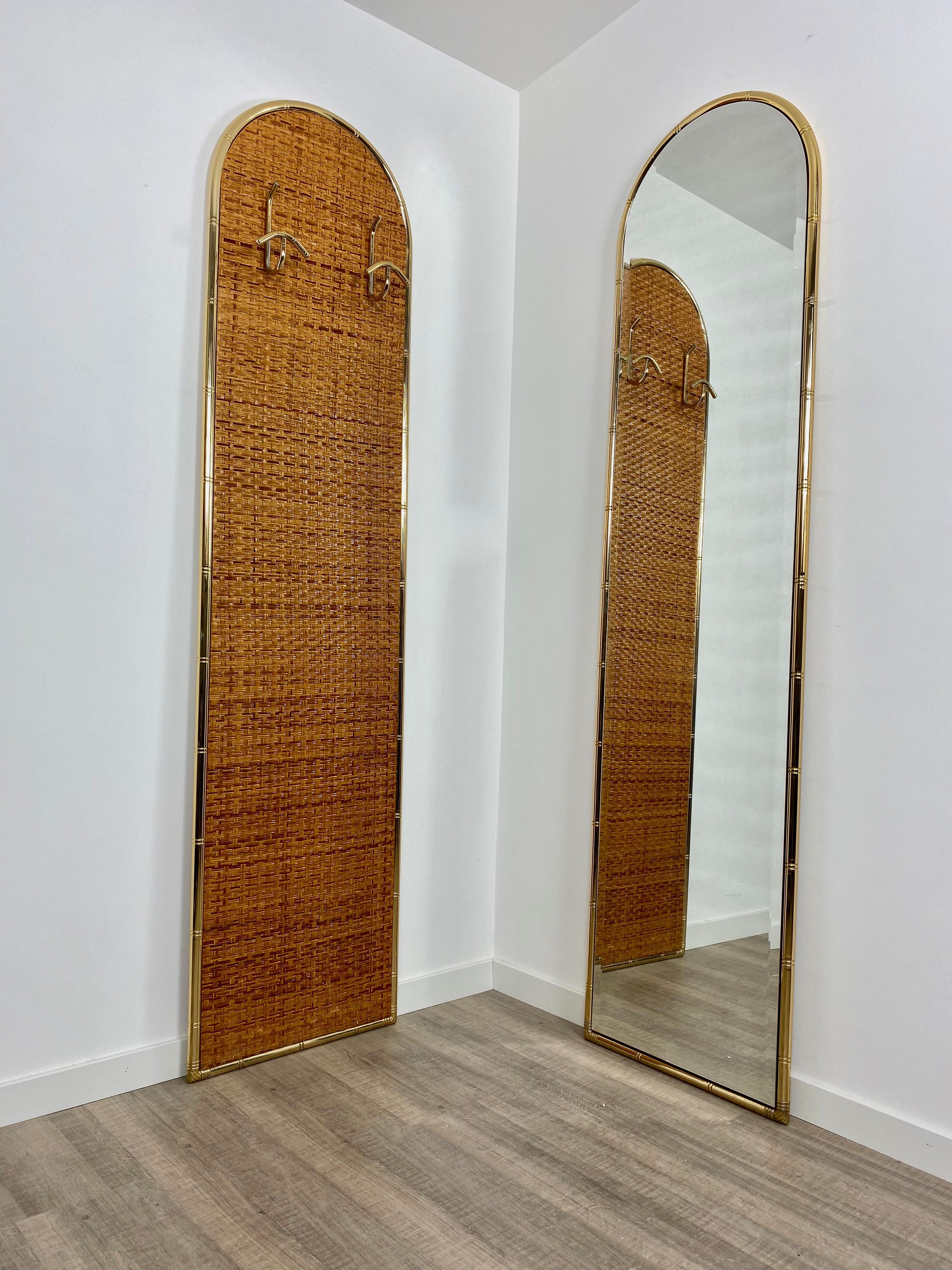 The set comes with a coat hanger in rattan and a golden metal structure (two hooks) and a wall mirror in identical shape and dimensions, with a golden frame. The set was made in Italy in the 1960s.