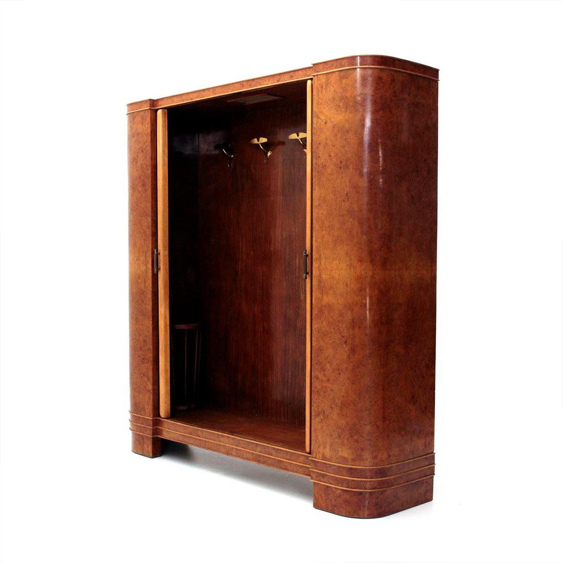 Entrance wardrobe, coat hanger of Italian manufacture produced in the 1940s.
Wooden structure veneered in briarwood.
Sliding doors made of wooden strips and decorated mirrors, brass handles.
Wood veneer interiors, brass hangers and wooden